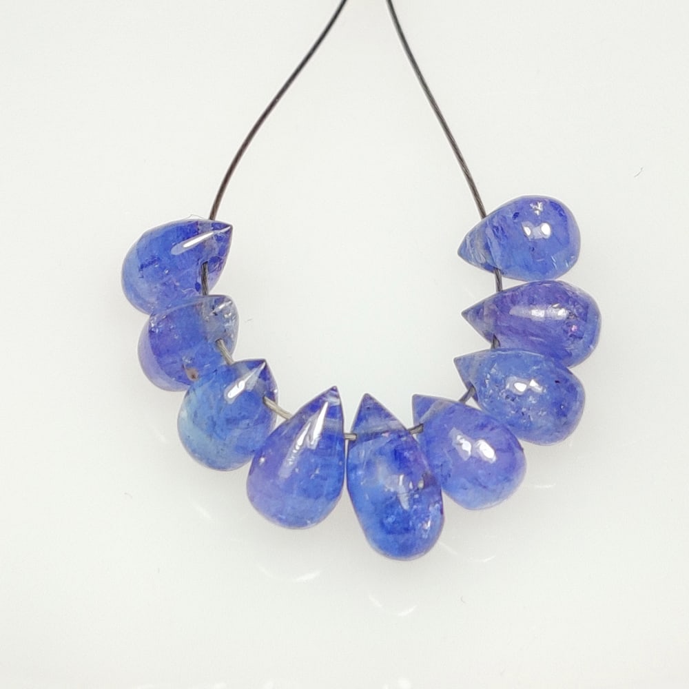 7.25 Ct Natural Tanzanite 9 Pear Drop Drilled Beads: Weight - 7.25 Ct / Size- 5.80 x 4.10 - 5.90 x 4.30 mm / 9 Pc's / Shape - Pear Drop Beads / Transparency - Transparent / Origin - Tanzania / Treatment - Standard Heated