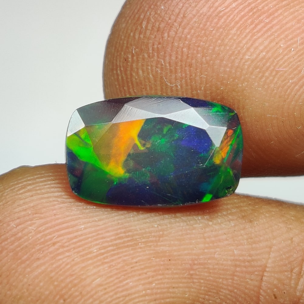 1.60 Ct Natural Black Flashing Fire Opal Cushion Cut: Weight - 1.60 Ct / Dimensions - 11.00 x 7.00 x 4.50 mm / Shape - Cushion Cut / Color - Black / Clarity - Translucent / Origin - Ethiopia / Treatment - Color Smoked