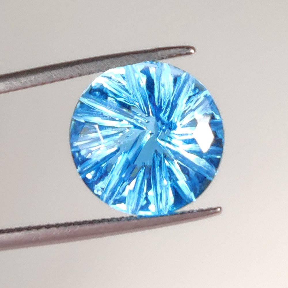 11.75 Ct Natural Blue Topaz Round Carving Cut: Weight - 11.75 Ct / Dimensions 14.00 x 14.00 x 8.60 mm / Shape Round Carving Cut / Color - Blue / Clarity - VVS / Origin - Brazil / Treatment - Irradiated