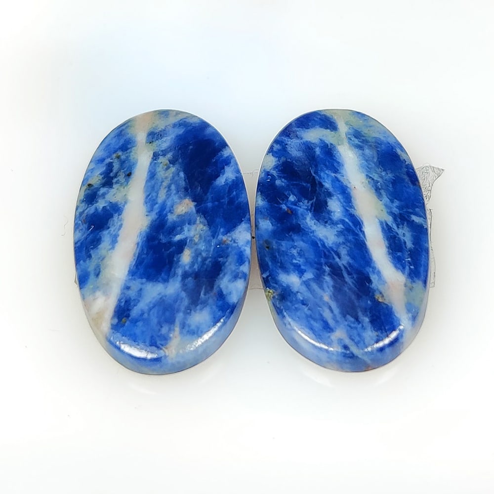 23.58 Ct Natural Sodalite Oval Pair: Weight -23.58 45.28 Ct / Dimensions - 26.00 x 14.70 x 3.70 mm / Shape - Oval Cabochon / Color - Blue / Clarity - Opaque / Origin -Brazil / Treatment - None
