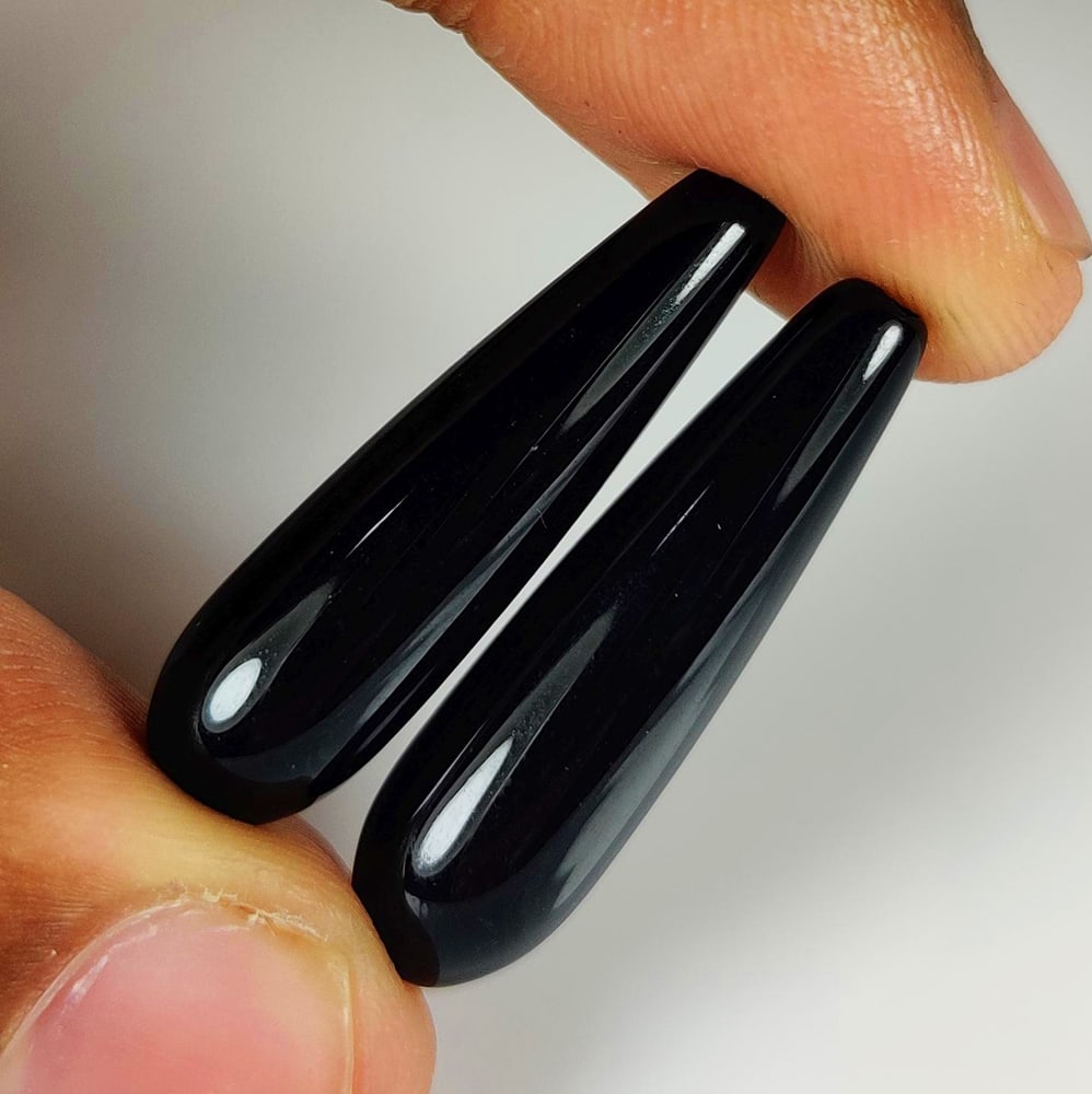 25.91 Ct Natural Black Onyx Fancy Pear Drop Pair: Weight - 25.91 Ct / Size - 30.00 x 8.20 x 8.20 mm / 2 PC's / Shape - Fancy Pear Drop / Color - Black / Clarity - OPaque / Origin - Africa / Treatment - None