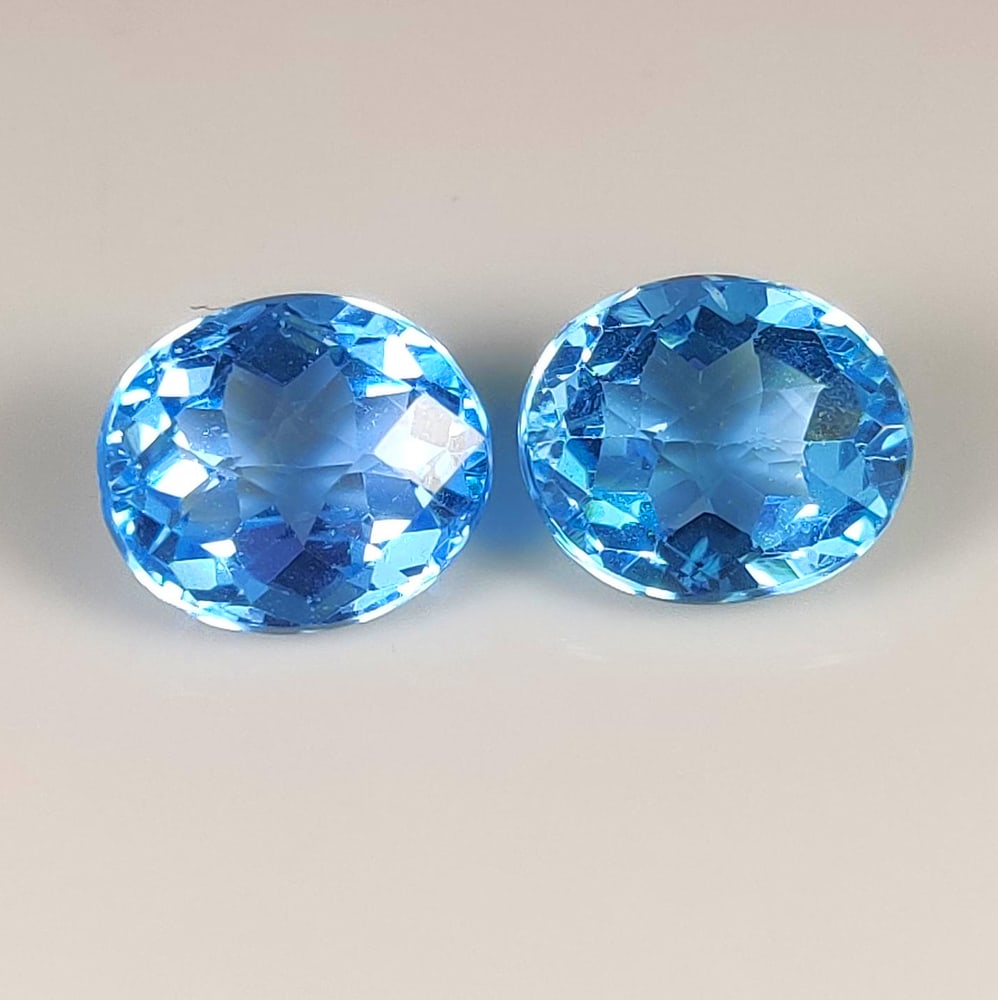 12.40 Ct Natural Blue Topaz Oval Cut Pair: Weight - 12.40 Ct / Size - 12.00 x 10.50 x 6.80 mm / 2 Pc's / Shape - Oval Cut / Color - Blue / Clarity - VVS / Origin - Brazil / Treatment - Irradiated