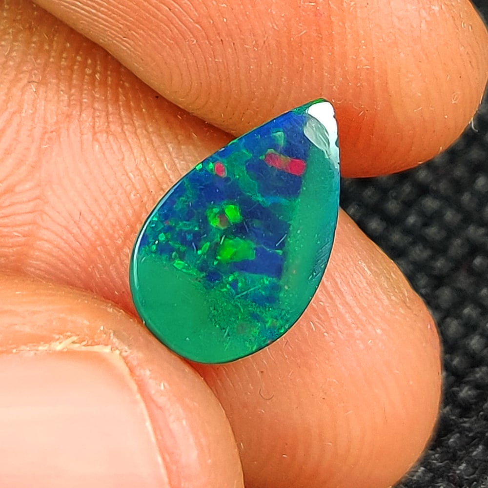 1.42 Ct Natural Black Flashing Fire Opal Pear Cab: Weight - 1.42 Ct / Dimensions - 11.80 x 7.40 x 4.00 mm / Shape - Pear Cab / Color - Black / Clarity - Translucent / Origin - Ethiopia / Treatment - Color Smoked