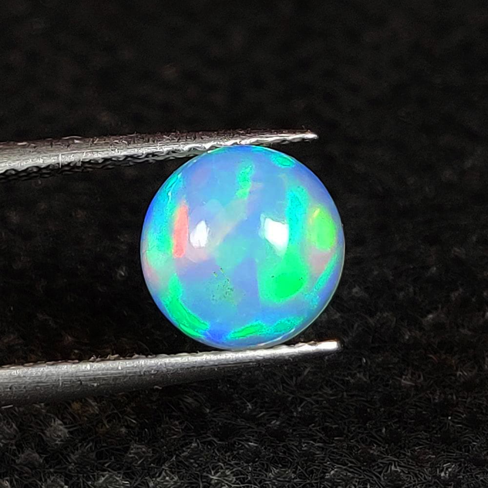 1.40 Ct Natural Multicolor Welo Opal Flash Fire Round Cab: Weight - 1.40 Ct / Dimensions - 8.10 x 8.10 x 4.70 mm / Shape & Cut - Round Cab / Color - Multicolor / Transparency - Translucent / Origin - Ethiopia / Comments - None