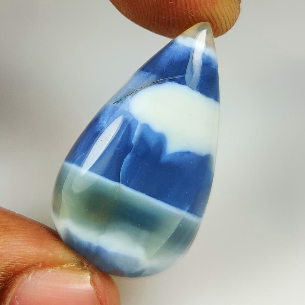 21.39 Ct Natural Owyhee Blue Opal Pear Cab: Weight - 21.39 Ct / Dimensions - 34.00 x 18.10 x 6.50 mm / Shape - Pear Cab / Clarity - Translucent / Origin - Africa / Treatment - None