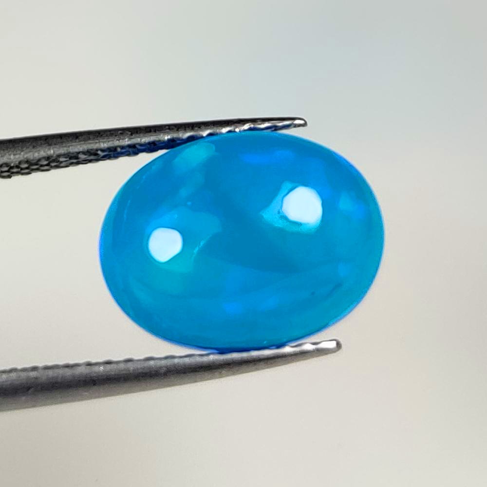 2.76 Ct Natural Blue Fire Opal Oval Cab: Weight - 2.76 Ct / Dimensions -12.10 x 9.10 x 5.30 mm / Shape - Oval Cab / Color - Blue / Clarity - Translucent / Origin - Ethiopia / Treatment - Heated