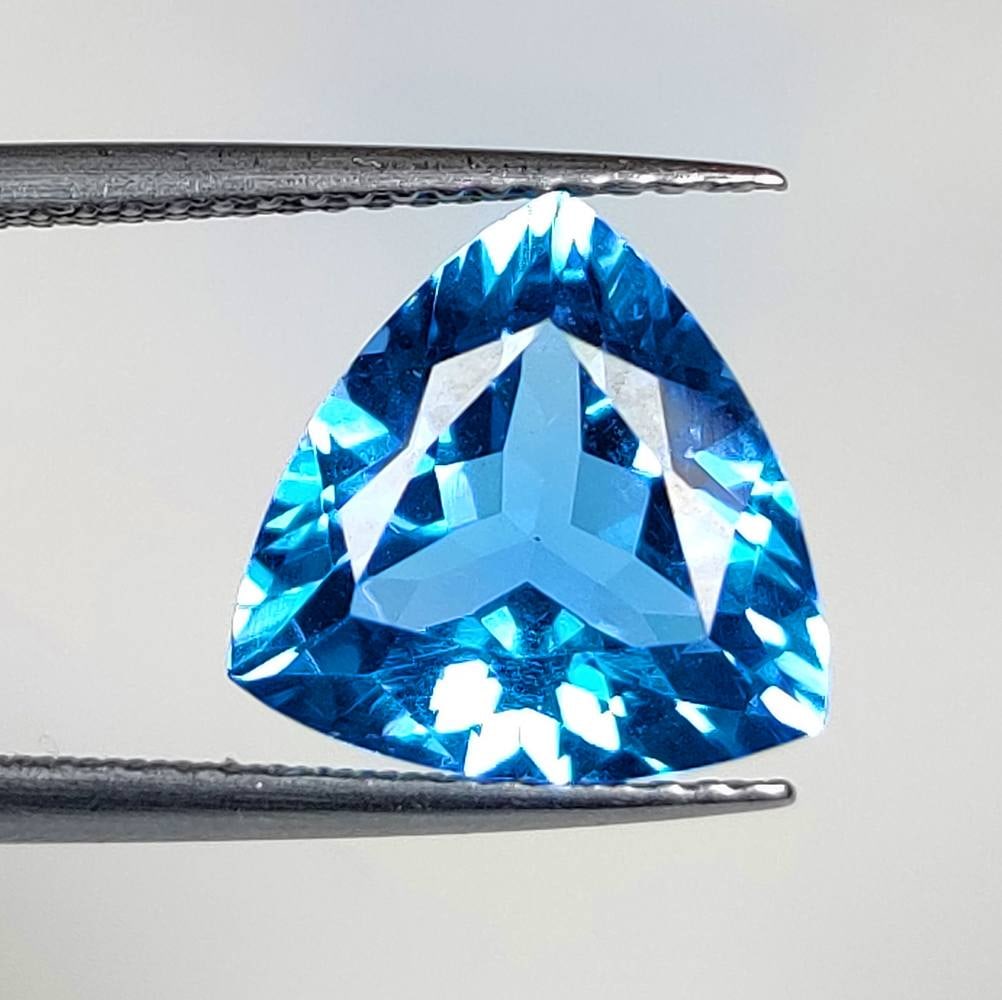 4.90 Ct Natural Blue Topaz Trillion Cut: Weight - 4.90 Ct / Dimensions - 11.20 x 11.10 x 6.20 mm / Shape - Trillion Cut / Color - Blue / Clarity - VVS / Origin - Brazil / Treatment - Irradiated
