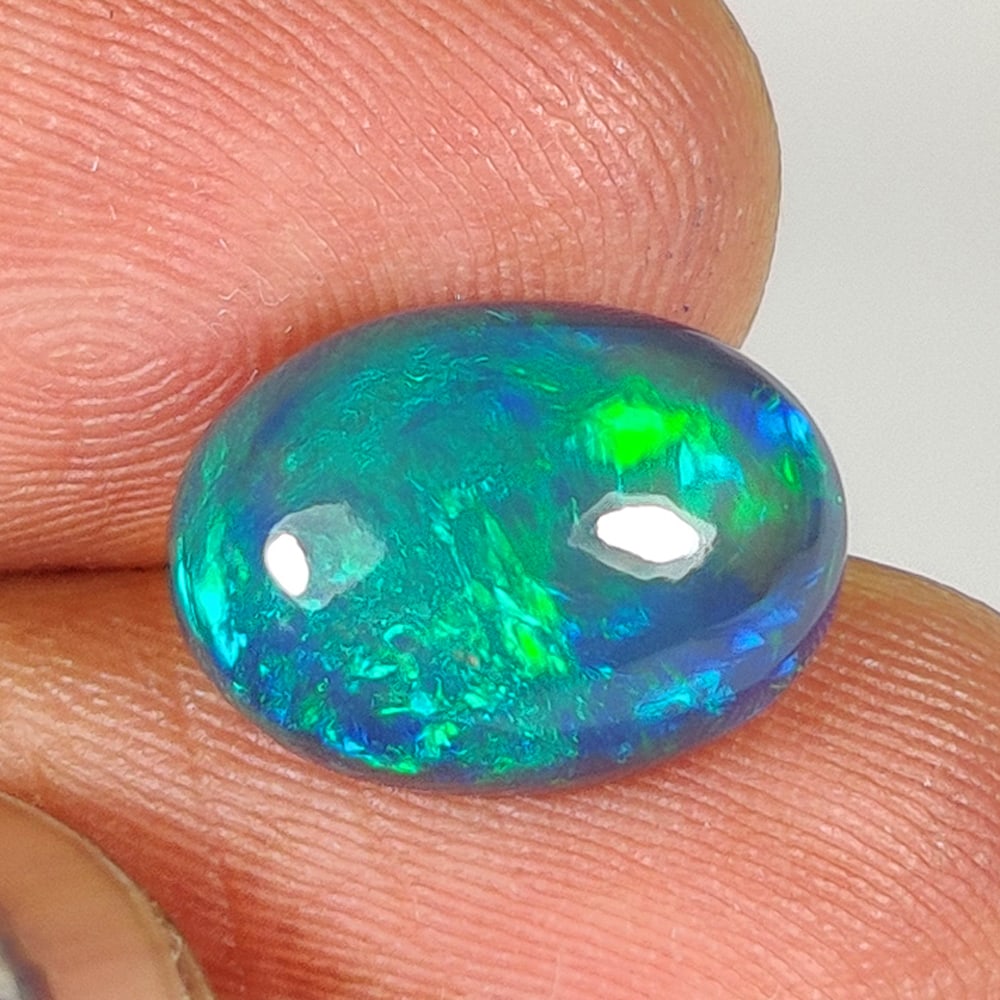 4.35 Ct Natural Black Flashing Fire Opal Oval Cab: Weight - 4.35 Ct / Dimensions - 12.80 x 9.40 x 6.90 mm / Shape - Oval Cab / Color - Black / Clarity - Translucent / Origin - Ethiopia / Treatment - Color Smoked