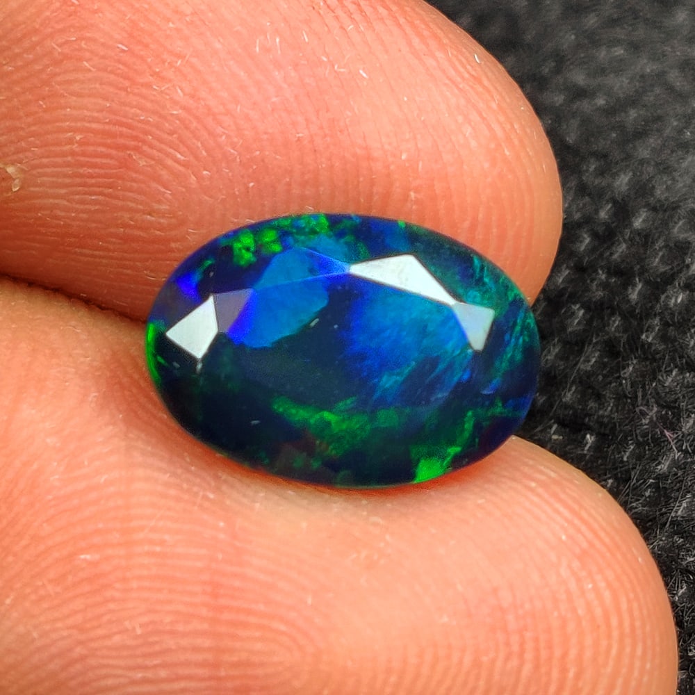 2.76 Ct Natural Black Flashing Fire Opal Oval Cut: Weight - 2.76 Ct / Dimensions - 12.90 x 9.00 x 5.40 mm / Shape - Oval Cut / Color - Black / Clarity - Translucent / Origin - Ethiopia / Treatment - Color Smoked