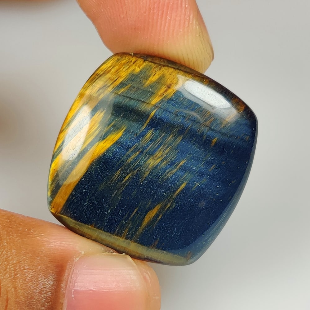 33.82 Ct Natural Black Tiger eye Cushion Cab: Weight - 33.82 Ct / Size - 27.00 x 25.40 x 5.40 mm / Shape - Cushion Cab / Color - Black Brown / Clarity - Opaque / Origin - Burma / Treatment - None