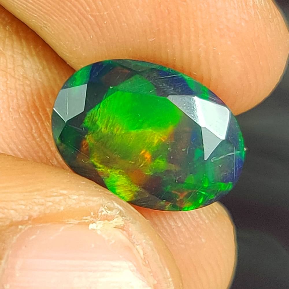 2.65 Ct Natural Black Flashing Fire Opal Oval Cut: Weight - 2.65 Ct / Dimensions -12.60 x 8.90 x 5.60 mm / Shape - OVal Cut / Color - Black / Clarity - Translucent / Origin - Ethiopia / Treatment - Color Smoked