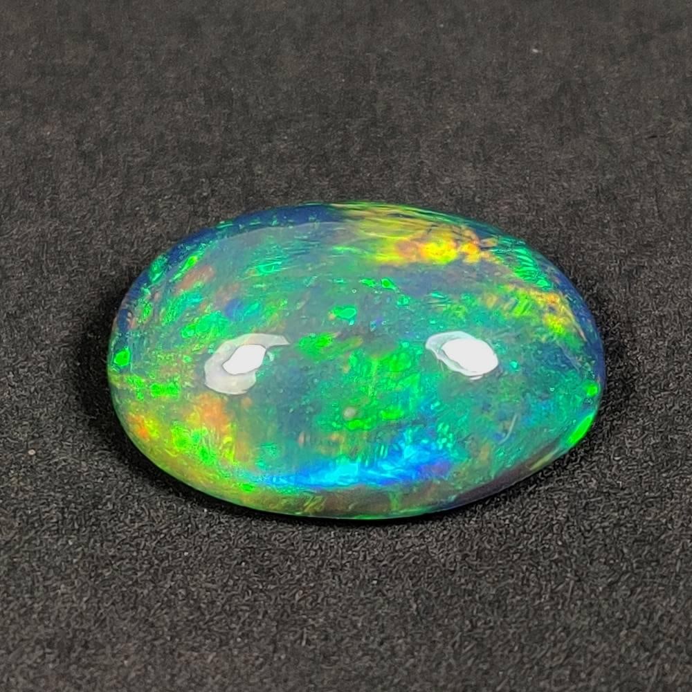 2.78 Ct Natural Black Flashing Fire Opal Oval Cab: Weight - 2.78 Ct / Dimensions - 13.40 x 9.60 x 4.70 mm / Shape - Oval Cab / Color - Black / Clarity - Translucent / Origin - Ethiopia / Treatment - Color Smoked