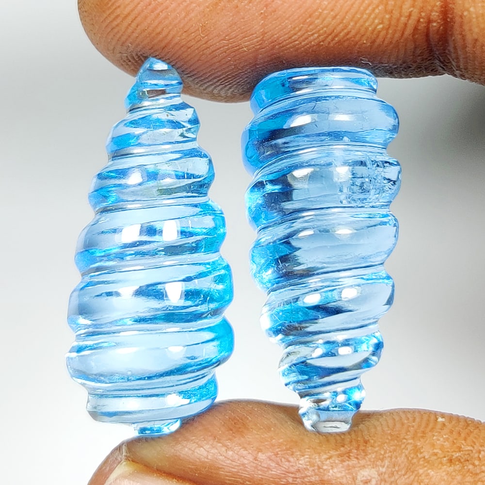 55.65 Ct Natural Blue Topaz Fancy Pear Carving Pair: Weight - 55.65 Ct / Dimensions - 25.00 x 12.00 x 12.00 mm / 2 PC's / Shape & Cut - Fancy Pear Carving / Color - Blue / Transparency - VVS / Origin - Brazil / Comments - Irradiated