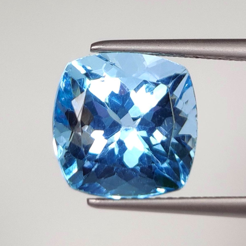 7.43 Ct Natural Blue Topaz Cushion Cut: Weight - 7.43 Ct / Size - 10.70 x 10.70 x 8.30 mm / Shape - Cushion Cut / Color - Blue / Clarity - VVS / Origin - Brazil / Treatment - Irradiated