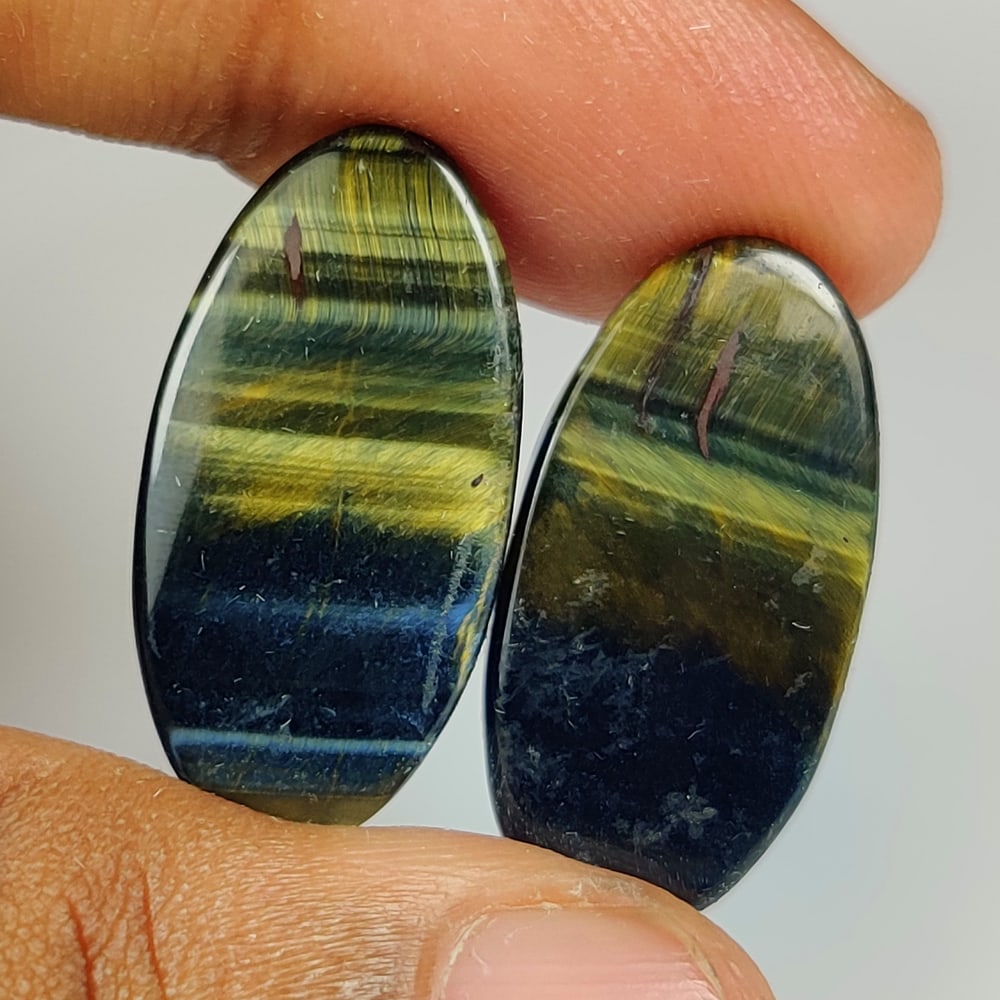 27.66 Ct Natural Blue Tiger Eye Oval Cab Pair: Weight - 27.66 Ct / Dimensions - 25.30 x 13.00 x 4.20 mm / 2 Pc's / Top Class Quality / Oval Cab / Origin - Burmese / Comments - None