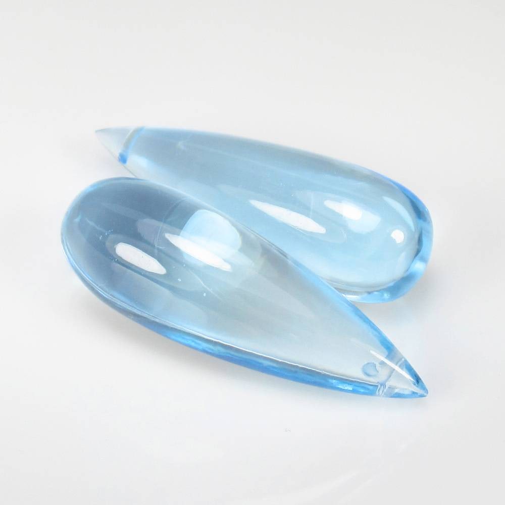 51.41 Ct Natural Swiss Blue Topaz Drilled Pear Drop Pair: Weight - 51.41 Ct / Dimensions - 29.50 x 10.10 mm / 2 Pc's / Shape & Cut - Pear Drop / Color - Blue / Transparency - VVS / Origin - Brazil / Comments - Irradiated