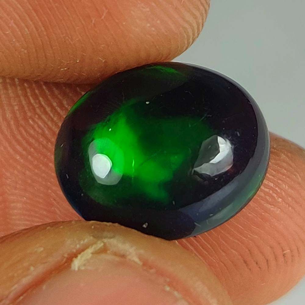 3.74 Ct Natural Black Flashing Fire Opal Oval Cab: Weight - 3.74 Ct / Dimensions - 12.70 x 10.80 x 5.90 mm / Shape - Oval Cab / Color - Black / Clarity - Translucent / Origin - Ethiopia / Treatment - Color Smoked