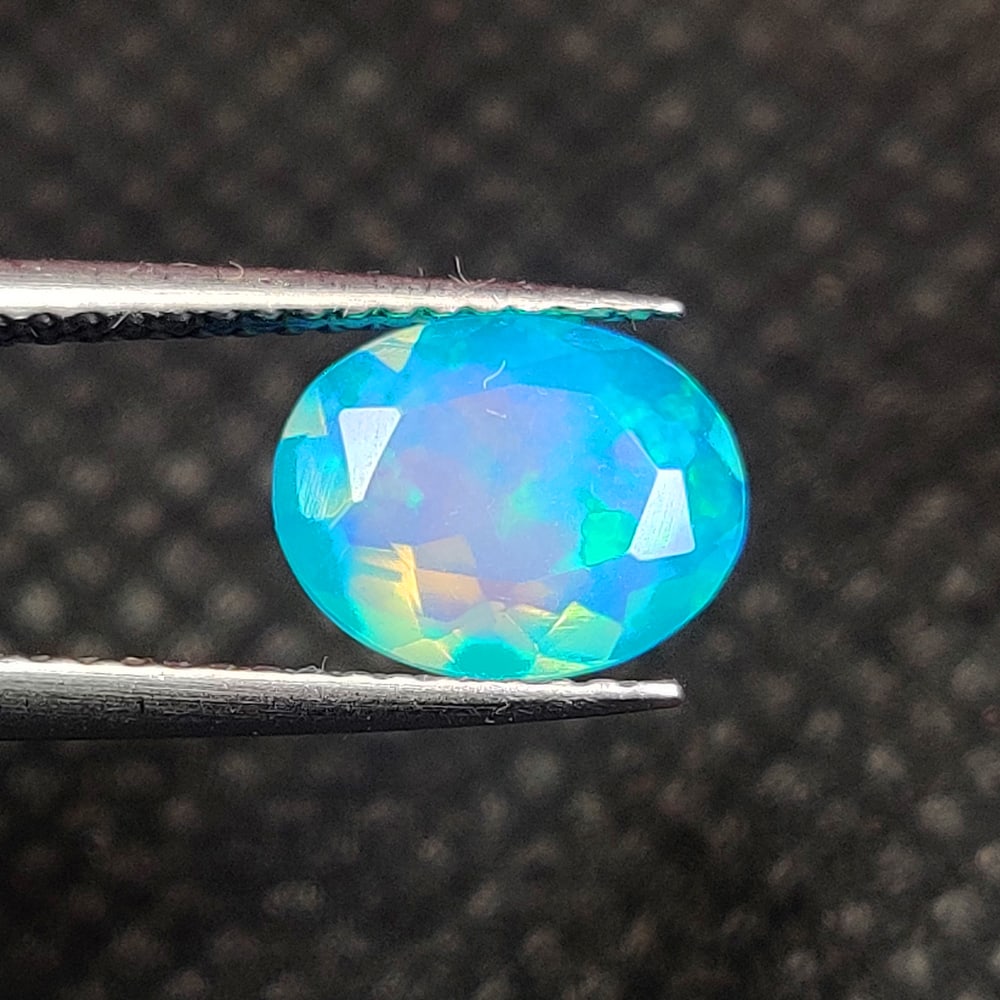 1.10 Ct Natural Blue Fire Opal Oval Cut: Weight - 1.10 Ct / Dimensions - 9.00 x 7.10 x 3.90 mm / Shape - Oval Cut / Color - Blue / Clarity - Translucent / Origin - Ethiopia / Treatment - Heated