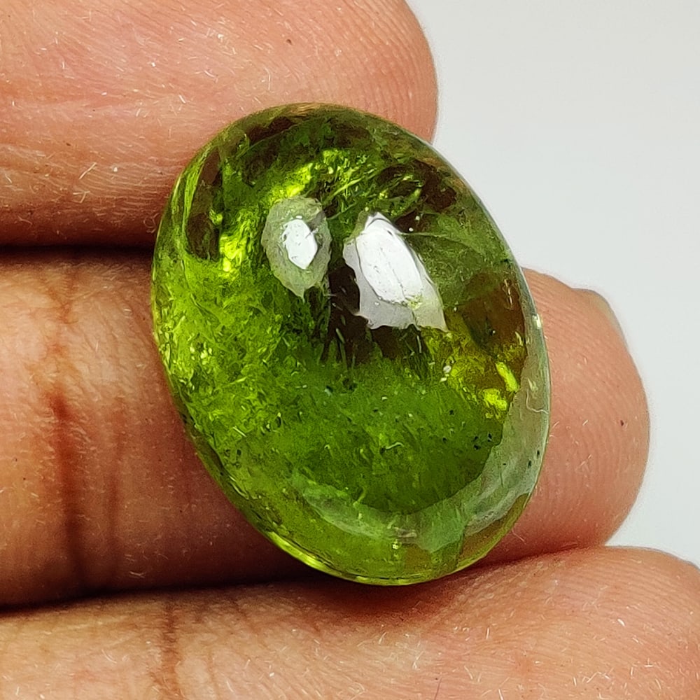 11.95 Ct Natural Green Peridot Oval Cab: Weight - 11.95 Ct / Dimensions - 17.10 x 12.70 x 6.30 mm / Shape - Oval Cab / Color - Green / Clarity - VVS / Origin - Pakistan / Treatment - None