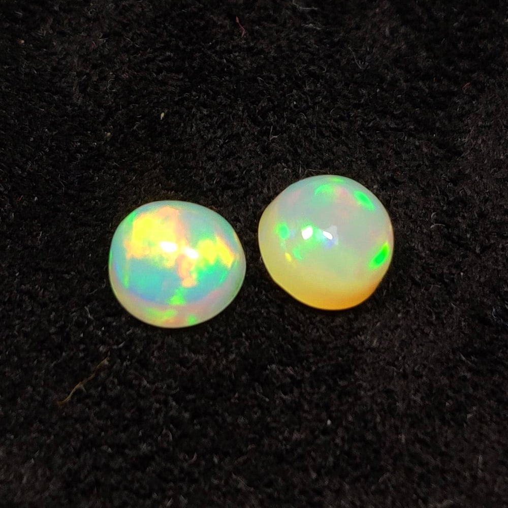 1.48 Ct Natural Multicolor Welo Opal Top Fire Round Cab Pair: Weight - 1.48 Ct / Size - 6.00 x 6.00 x 3.90 mm / 2 Pc's / Shape - Round Cab / Color - Multicolor / Clarity - Translucent / Origin - Ethiopia / Treatment - None