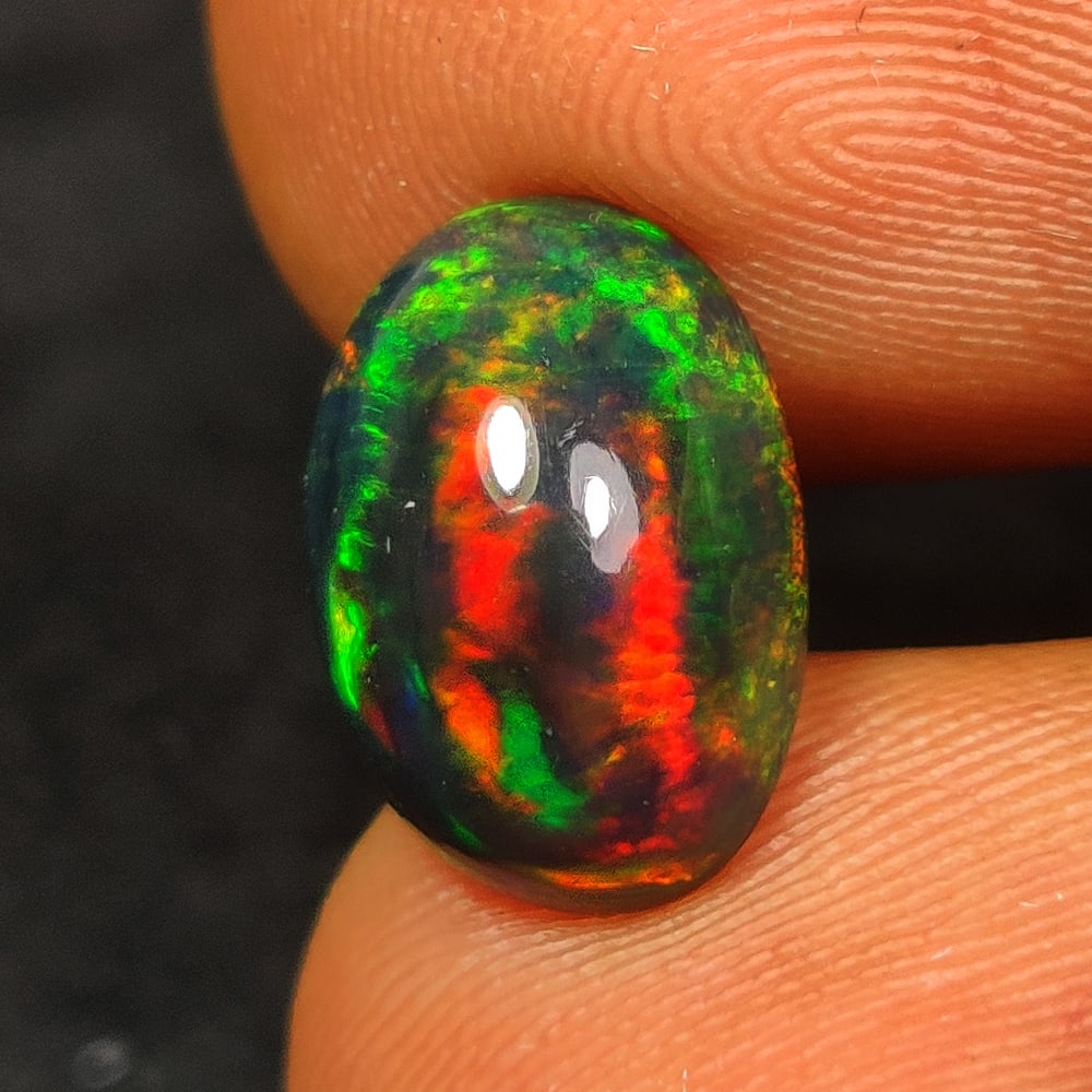 1.93 Ct Natural Black Flashing Fire Opal OVal Cab: Weight - 1.93 Ct / Dimensions - 11.00 x 7.80 x 5.20 mm / Shape - OVal Cab / Color - Black / Clarity - Translucent / Origin - Ethiopia / Treatment - Color Smoked