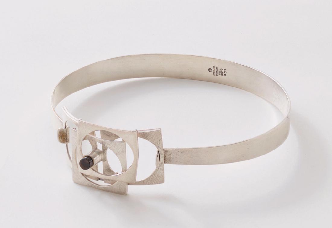 Bent Knudsen, Daenemark, Halsreif/ Collier: 1970er Jahre, Silber, Amethyst. Halsreif mit leicht umgeschlagenen Enden, dort zentrales, aus vier uebereinander angeordneten Quadraten mit kreisfoermigen Oeffnungen gebildetes Mittelstueck mit kleine