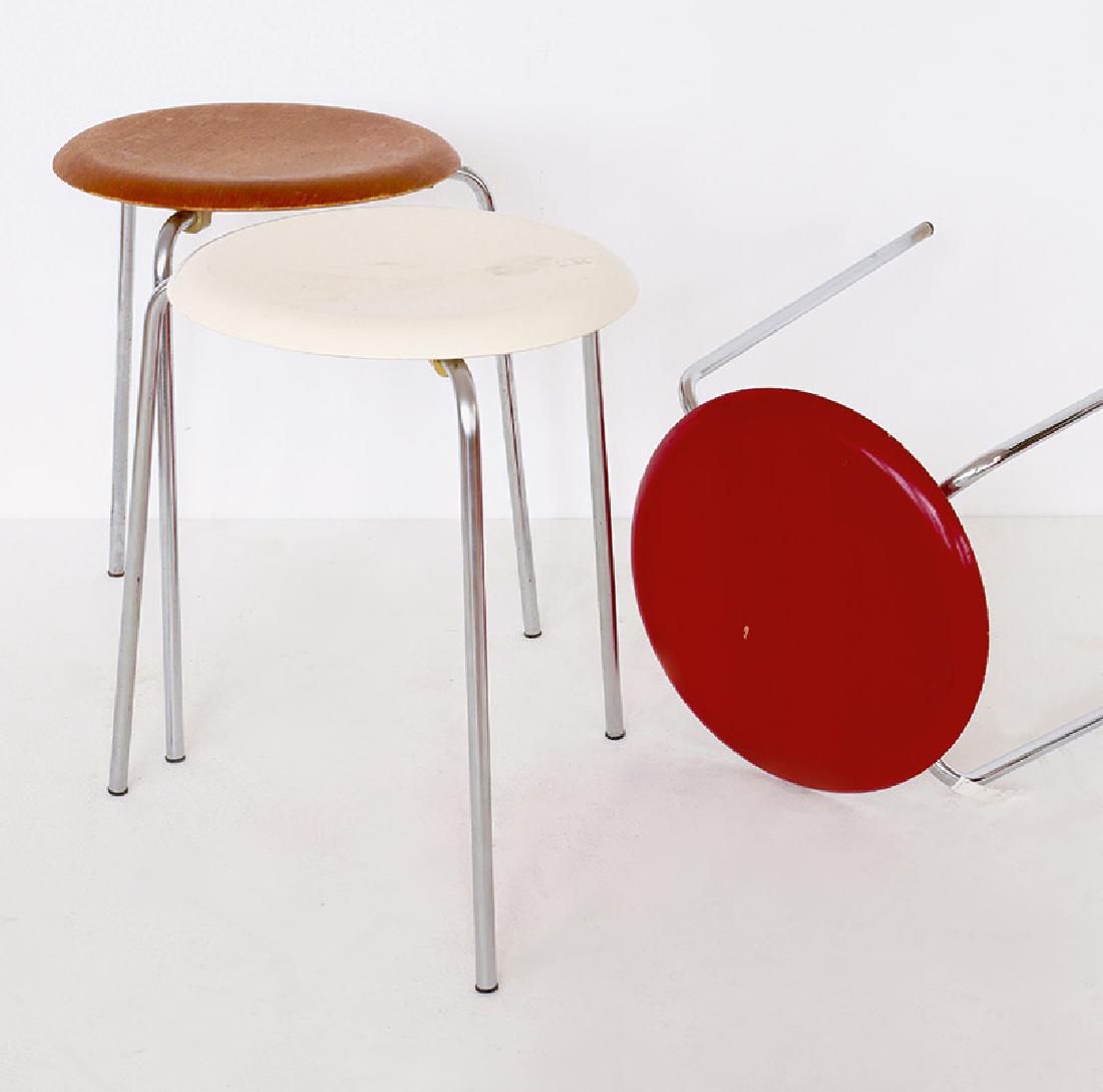 3 stools Dot, Arne Jacobsen, Fritz Hansen: Teak and plywood, painted red and white. Metal tube frame. Three-legged form, red stool with four legs. H. 46 cm, D. 33 cm (seat). On the underside marked with company brand and company label., Design