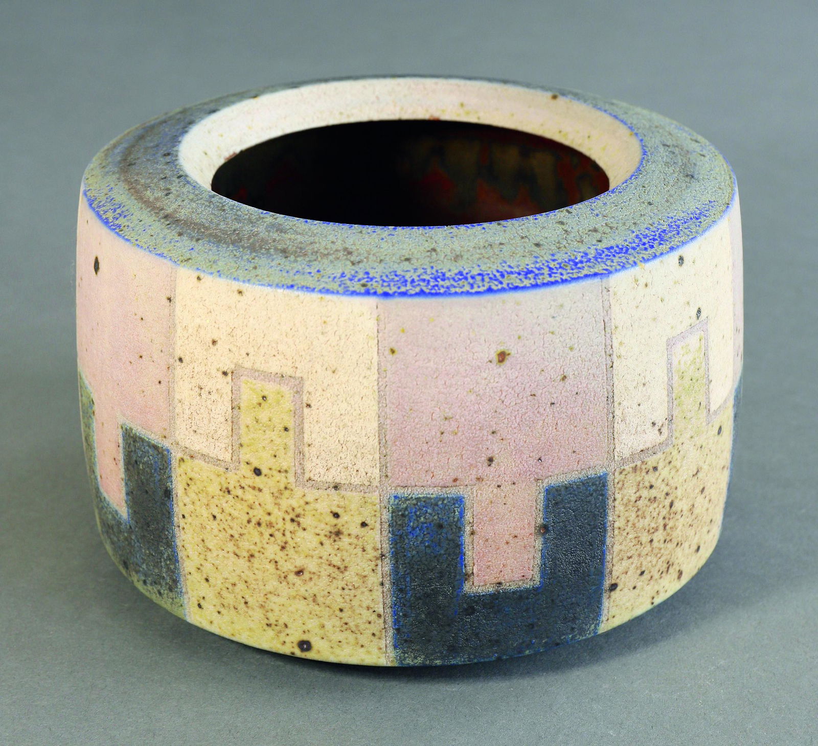 Ursula Scheid, Vase/ Bowl: Ursula Scheid, Vase / bowl. 1998. stoneware. Matt, slightly rough glaze. Geometric polychrome decor, partially blue and pink, speckled brown. Cylindrical shape. H. 11 cm, D. 16 cm. Marked on the botto