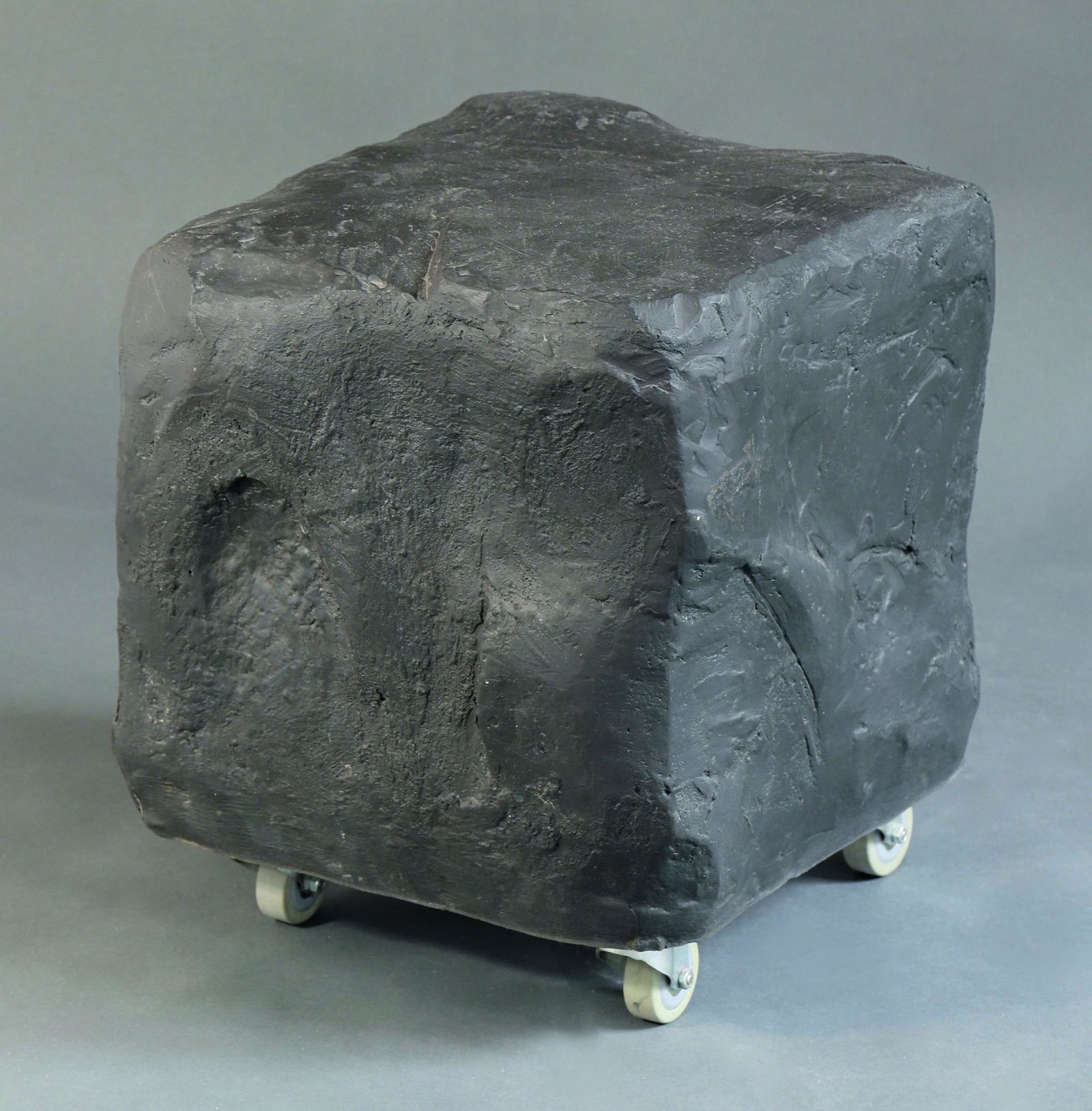 Volker Albus, Stool Model Cobblestone / Kopfstein: Volker Albus, Rolling stool model Kopfstein / Cobblestone. Designed 1987/88. Black hard rubber, metal plate with rollers. 41 x 36 x 34 cm., Literature: Dieter Bechtloff, Kunstforum International, Bd.