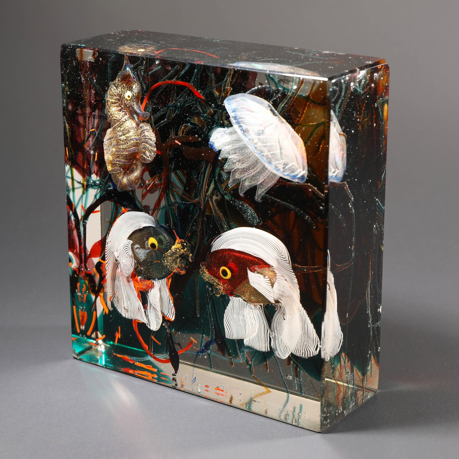 Gino Cenedese, Aquarium: Designed around 1960. Executed by Gino Cenedese, Murano. Colorless glass with multicolored fusions, two fish, jellyfish and seahorse. H. 17.5 x 6 x 16 cm.