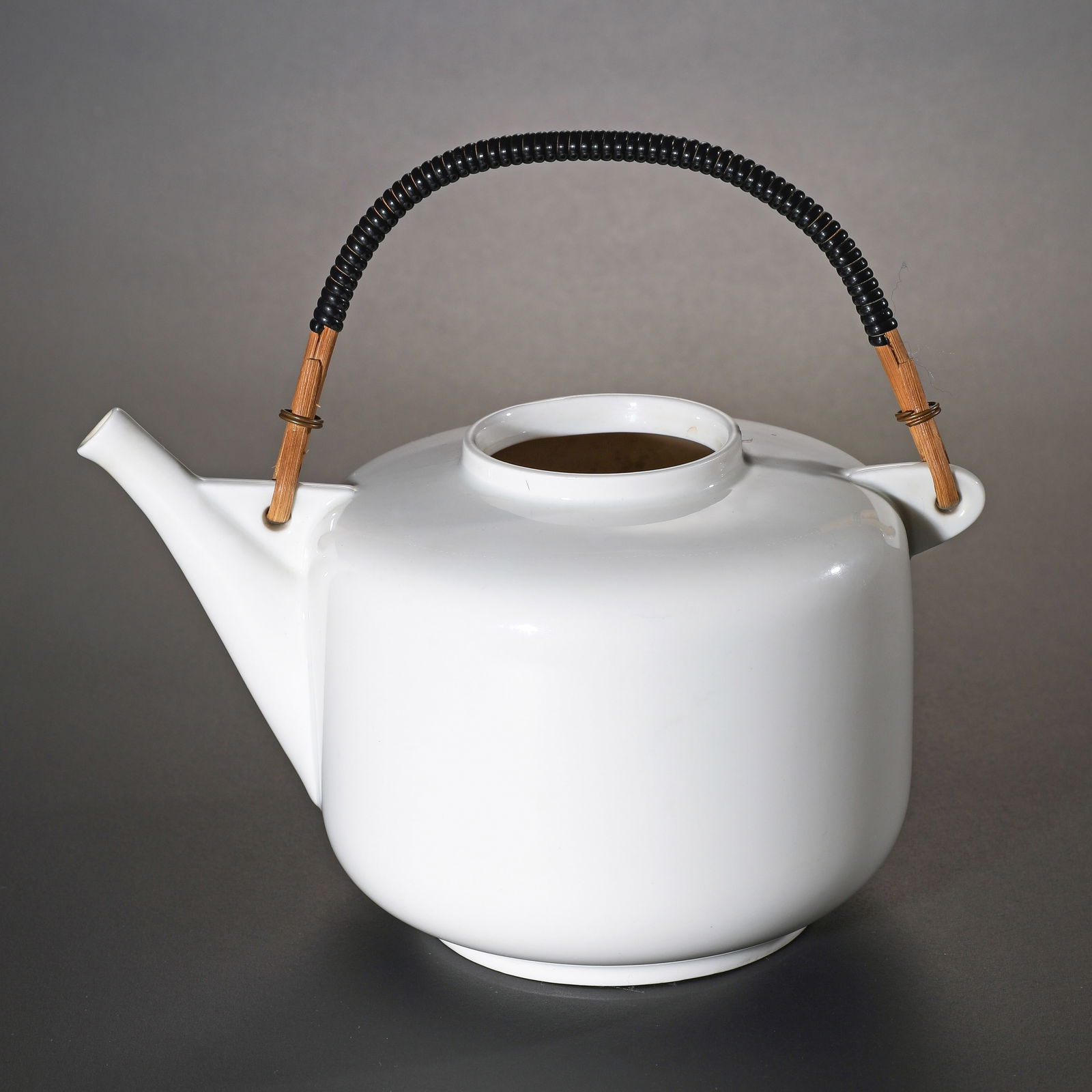 Gerhard Marcks, teapot: Designed around 1932. Ceramic with wrapped raffia handle. Made by Rhenania Porzellanfabrik GmbH in Bonn-Duisdorf. 11 x 21 x 14 cm. Marked on the underside with the manufacturer's mark and 'Western Ger