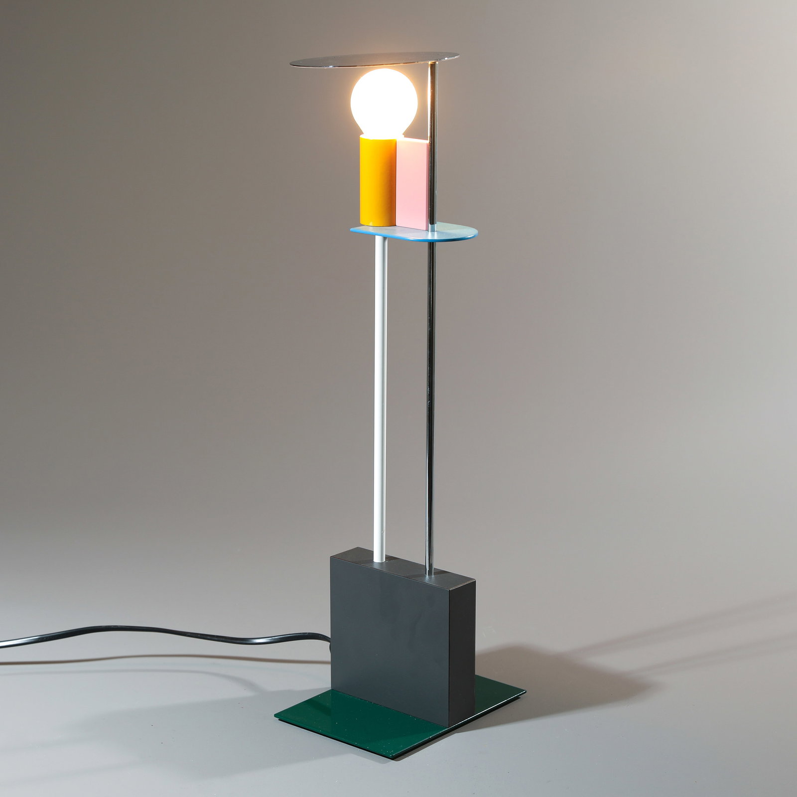 Gerard Taylor, Table lamp model Piccadilly: Gerard Taylor Designed in 1982. Execution Memphis. Lacquered and chrome-plated metal. 46.5 x 15 x 11 cm. Marked with Memphis metal plaque. Constance Rubini, Mermphis - Plastic Field, Bordeaux 2019, Ab