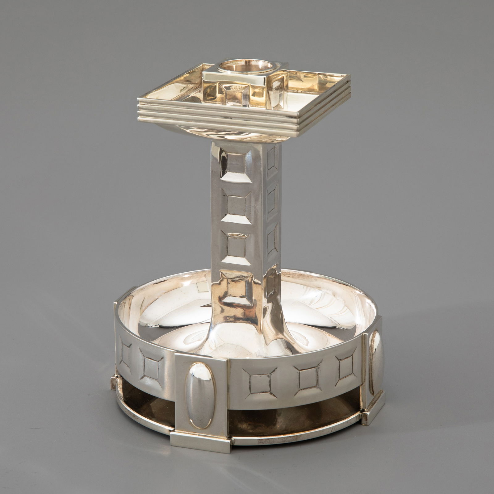 Hugo Leven, Candlestick: Designed in 1905. Manufactured by Koch & Bergfeld, Bremen. Model no. 47077. Silver. A very rare candlestick. Architectural construction with coffered ornamentation. Bowl-like base on four rectangular