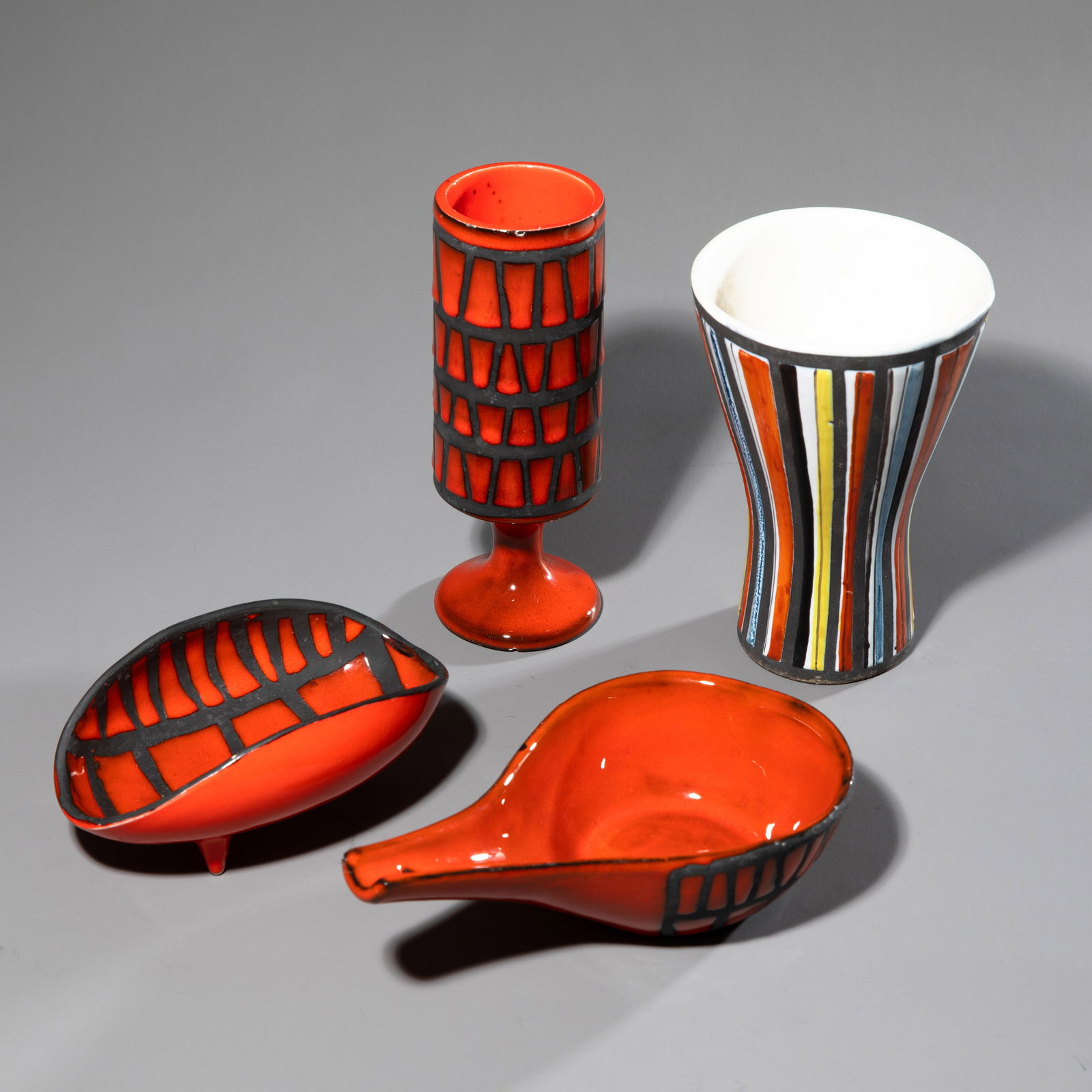 Roger Capron, 4 ceramic vessels: Two bowls with geometric decoration made of red enamel on a black background. A goblet with the same decoration on the cylindrical cup. One vase with raised, vertical sections on the wall and painted