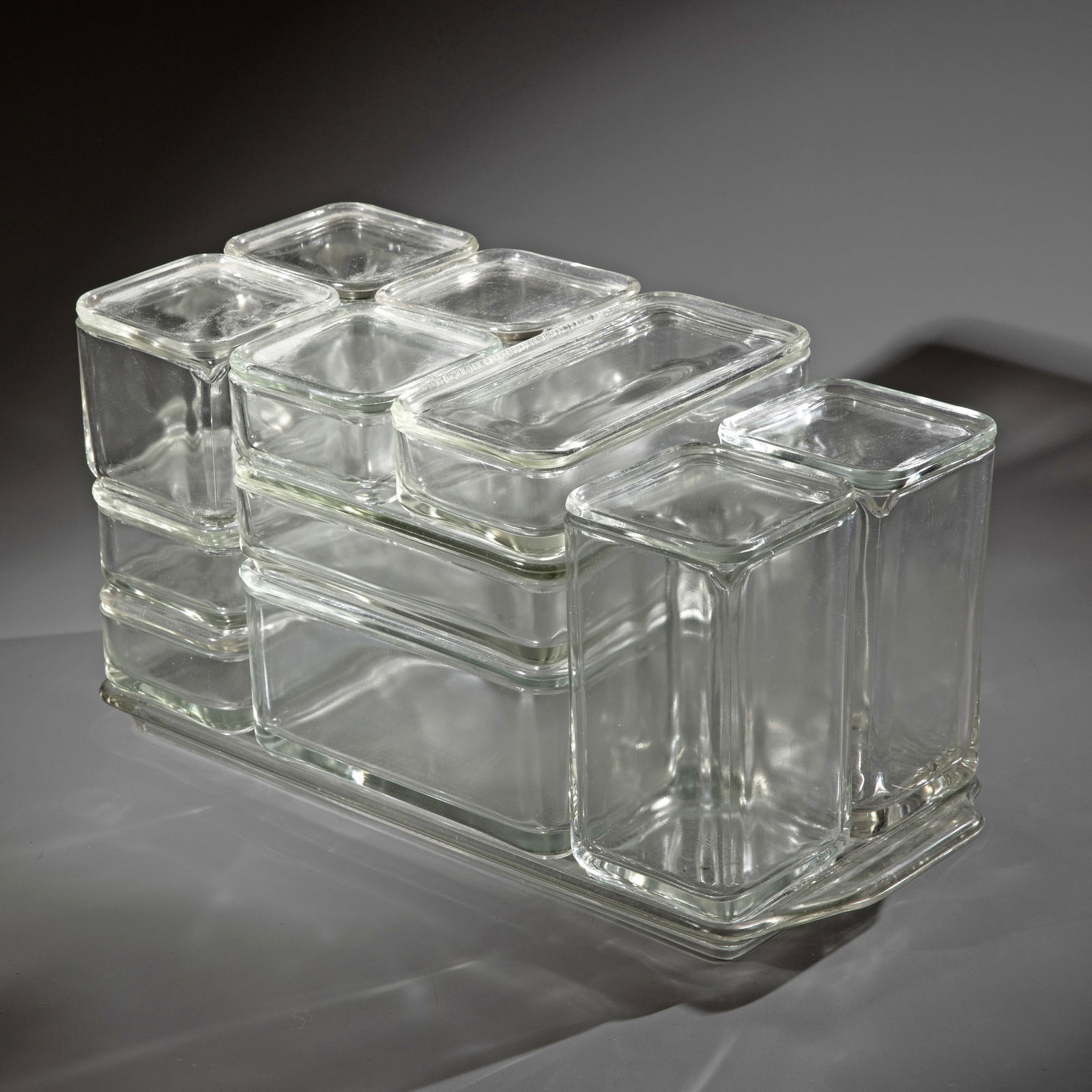 Wilhelm Wagenfeld, Rare, large tray with cube tableware 12 pieces: Wilhelm Wagenfeld Designed in 1938. Produced by VLG AG, Weißwasser until 1948. Clear pressed glass. Tray: 3 x 40.5 x 18 cm. Cube crockery block: 20 x 36 x 18 cm. Except for a small jug, all piec
