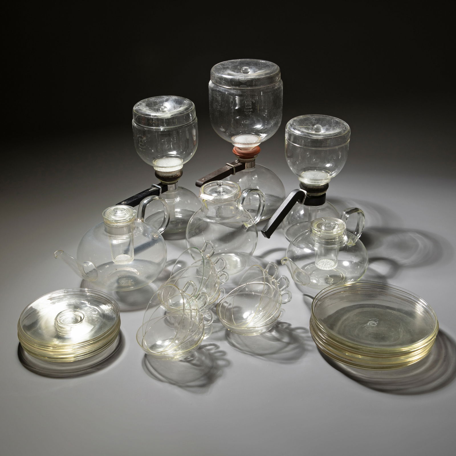 Wilhelm Wagenfeld, Christian Dell, Gerhard Marcks, Set of Jena glass pieces plus tea infuser: Wilhelm Wagenfeld & Christian Dell & Gerhard Marcks Two teapots, a tea service, three Sintrax coffee makers, a hot chocolate pitcher, and a tea strainer/tea egg. Designs from the 1920s and 1930s. Manu