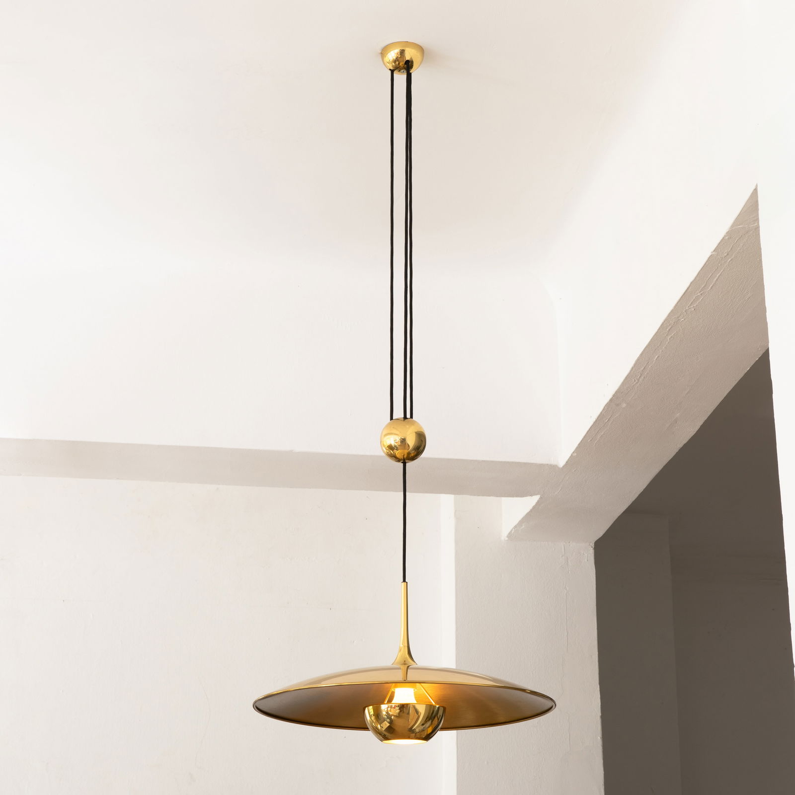 Florian Schulz, Counterweight pendant light model Onos 55: Florian Schulz Designed in the 1960s/70s. Manufactured by Florian Schulz GmbH. Polished brass with black fabric cable. H. 30 cm, D. 55 cm. Cable length approx. 120-240 cm.