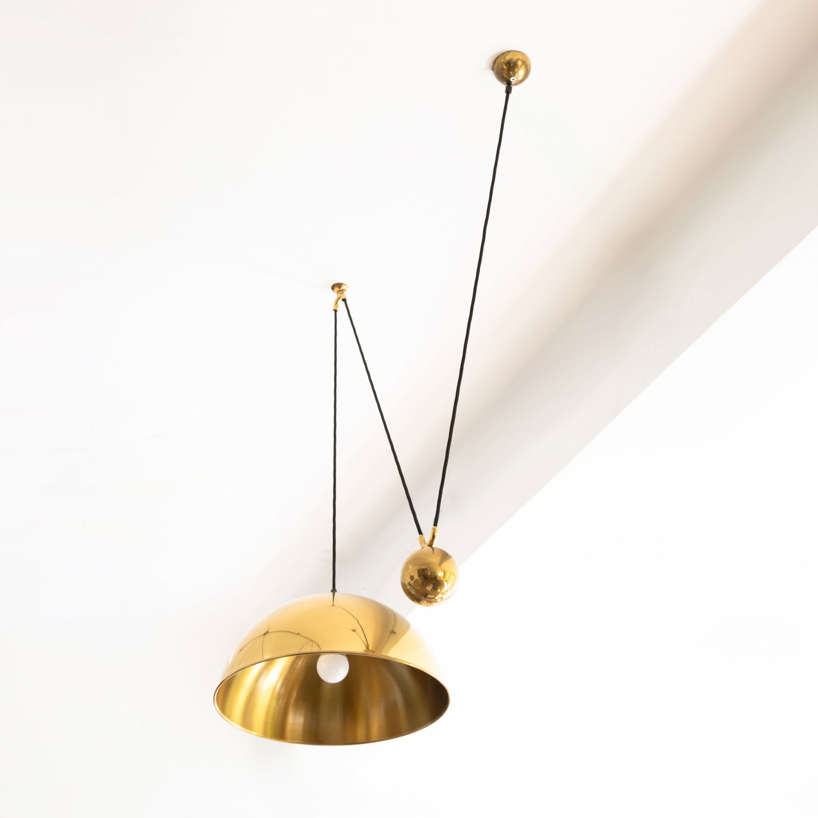Florian Schulz, Counterweight pendant light model Posa: Florian schulz Designed in the 1960s/70s. Manufactured by Florian Schulz GmbH. Polished brass, black fabric cable. H. 45-190, D. 43 cm.