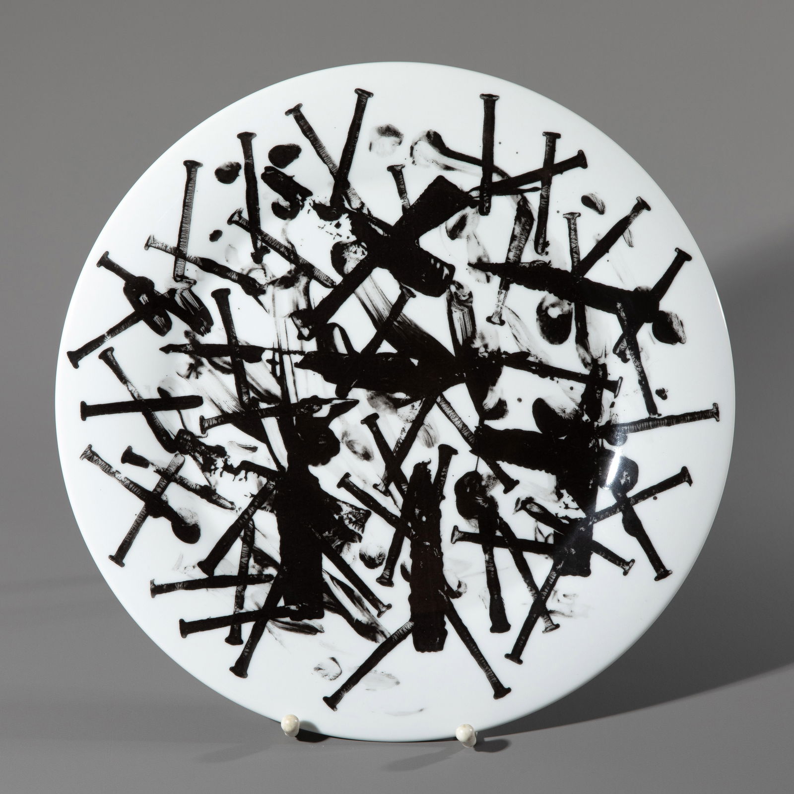 Günther Uecker* (1930-2025), Pain-setter 'Pein', 2007: Günther Uecker Porcelain with black imprint and nail decoration. D. 31.5 cm. Numbered, titled, and signed on the underside: YEAR PLATE 2007 / 158/250 / Pain Plate 'pein' / Uecker signature / G&uu