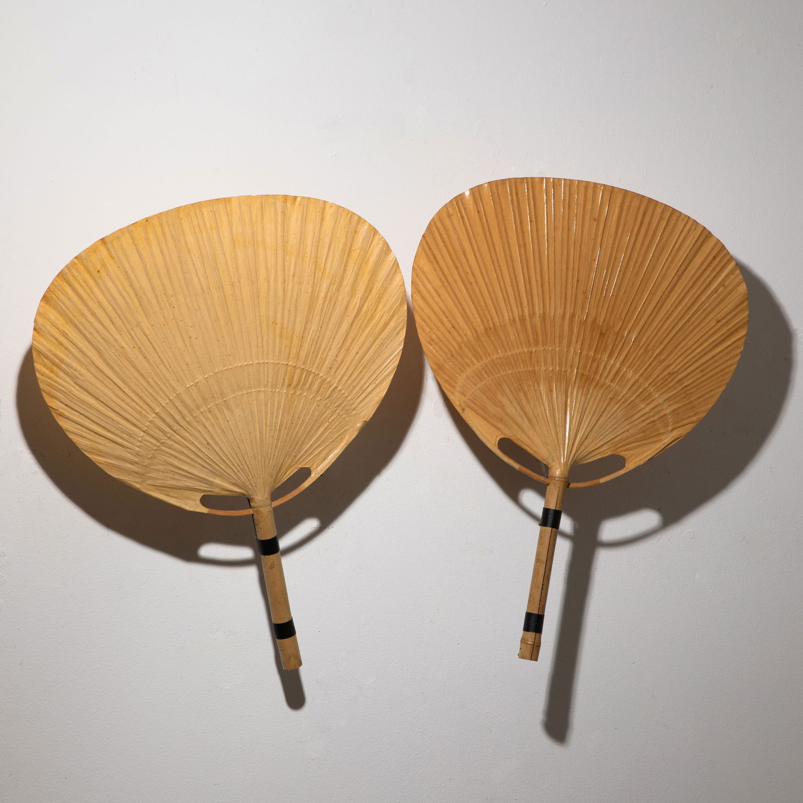 Ingo Maurer, 2 wall lights model Uchiwa: Ingo Maurer Designed in the 1970s. Manufactured by Design M. Bamboo, rice paper and metal. 73/75 x 57 x 17 cm. Both pieces are marked with a company sticker. Helmut Bauer, Ingo Maurer: Making Light, M