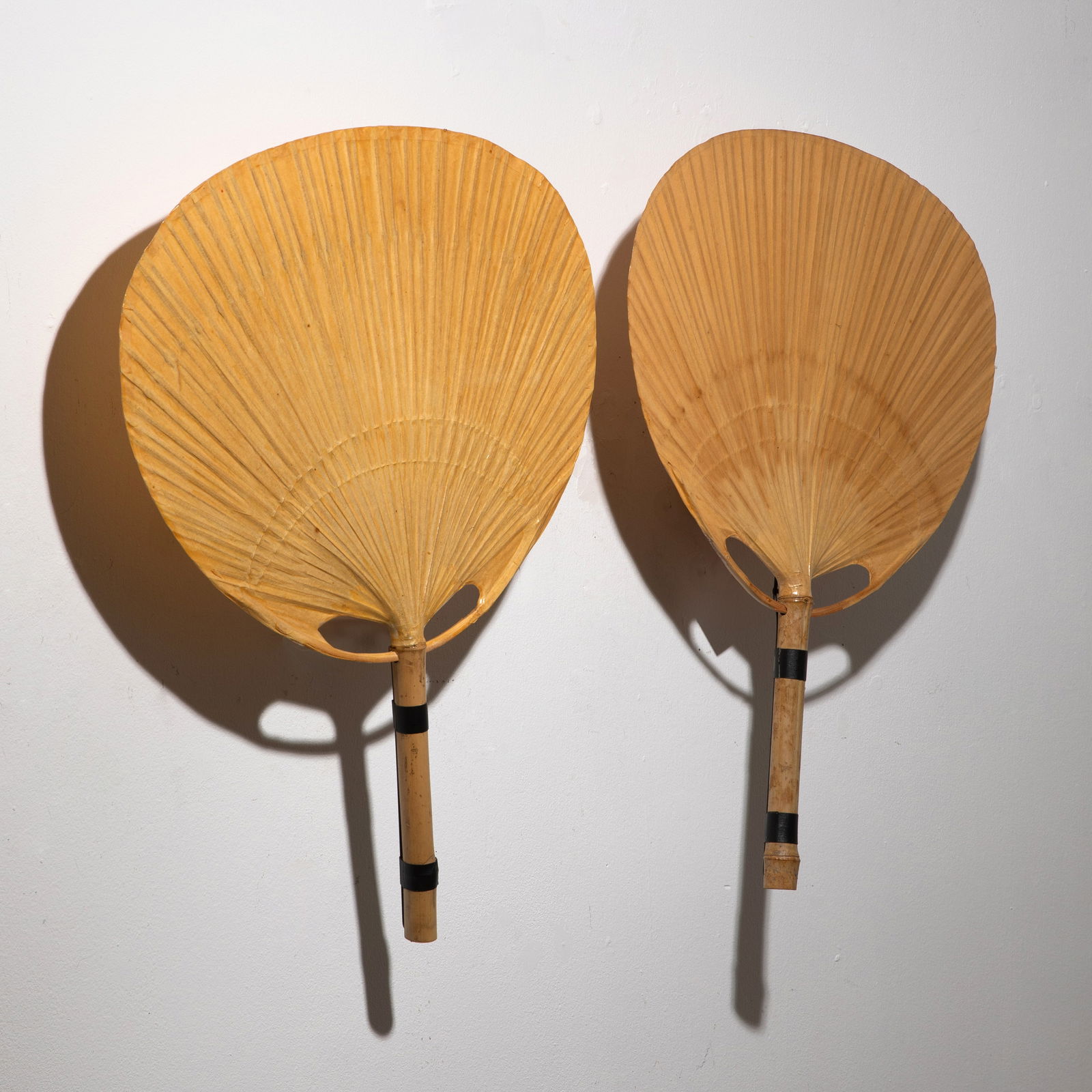 Ingo Maurer, 2 wall lights model Uchiwa: Ingo Maurer Designed in the 1970s. Manufactured by Design M. Bamboo, rice paper and metal. 74/75 x 57 x 17 cm. One object is marked with a company sticker.