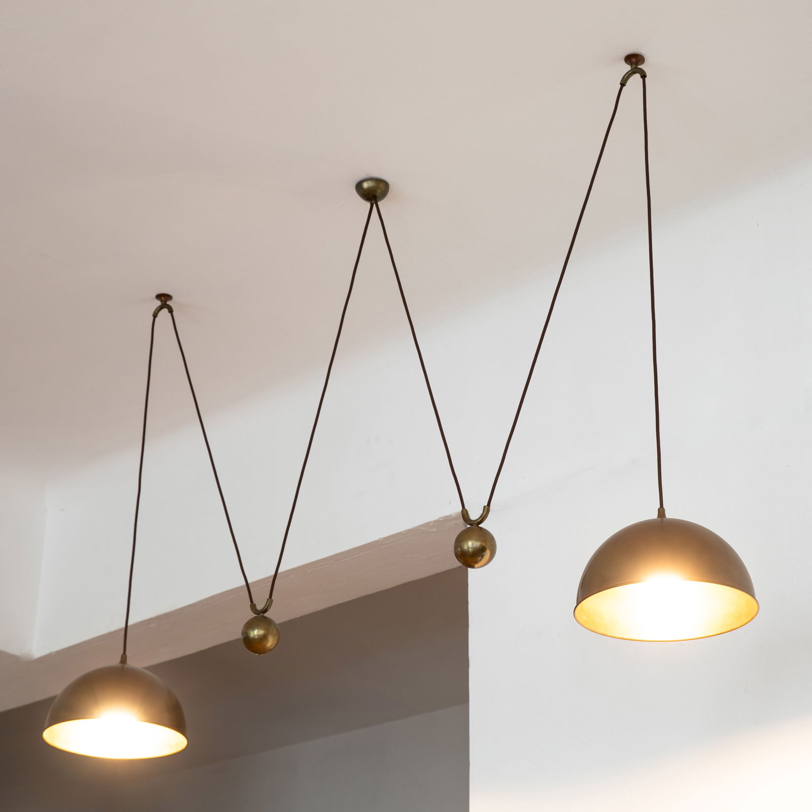 Florian Schulz, >Double pull pendant lamp model Posa: Florian Schulz Designed in the 1960s/70s. Manufactured by Florian Schulz GmbH. Burnished brass, black fabric cable. Reflector dimensions: H. 19 cm, D. 31 cm.