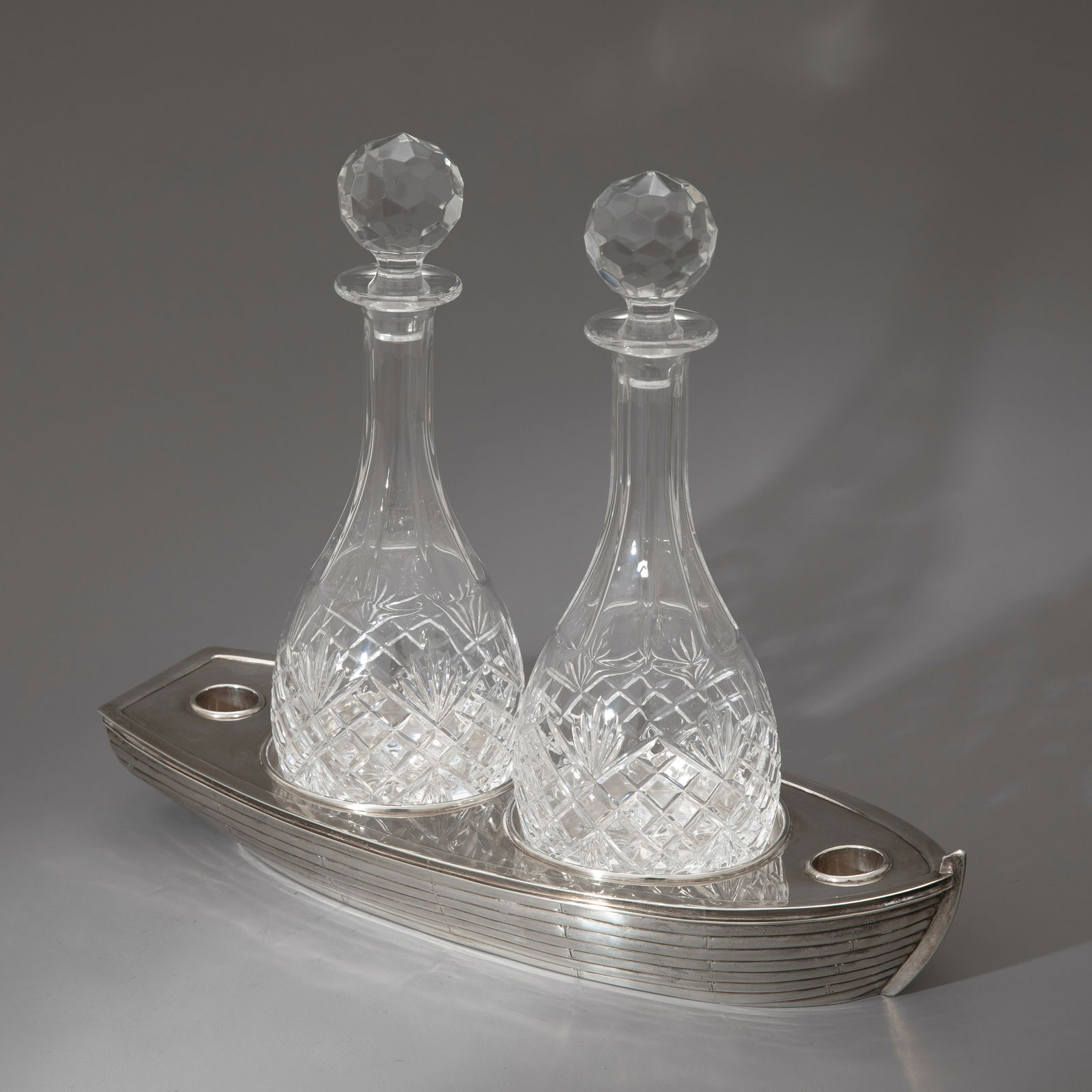 Richard Comyns Ltd., London, Liqueur set with two carafes, 1986: Sterling silver. Cut crystal glass. Approx. 2,400 grams of silver. H. 7.9 x 44 x 17.5 cm, H. 33 cm. Stamped: Workshop mark RC, lion passant, leopard's head, year letter M, Comyns London. Provenance: E