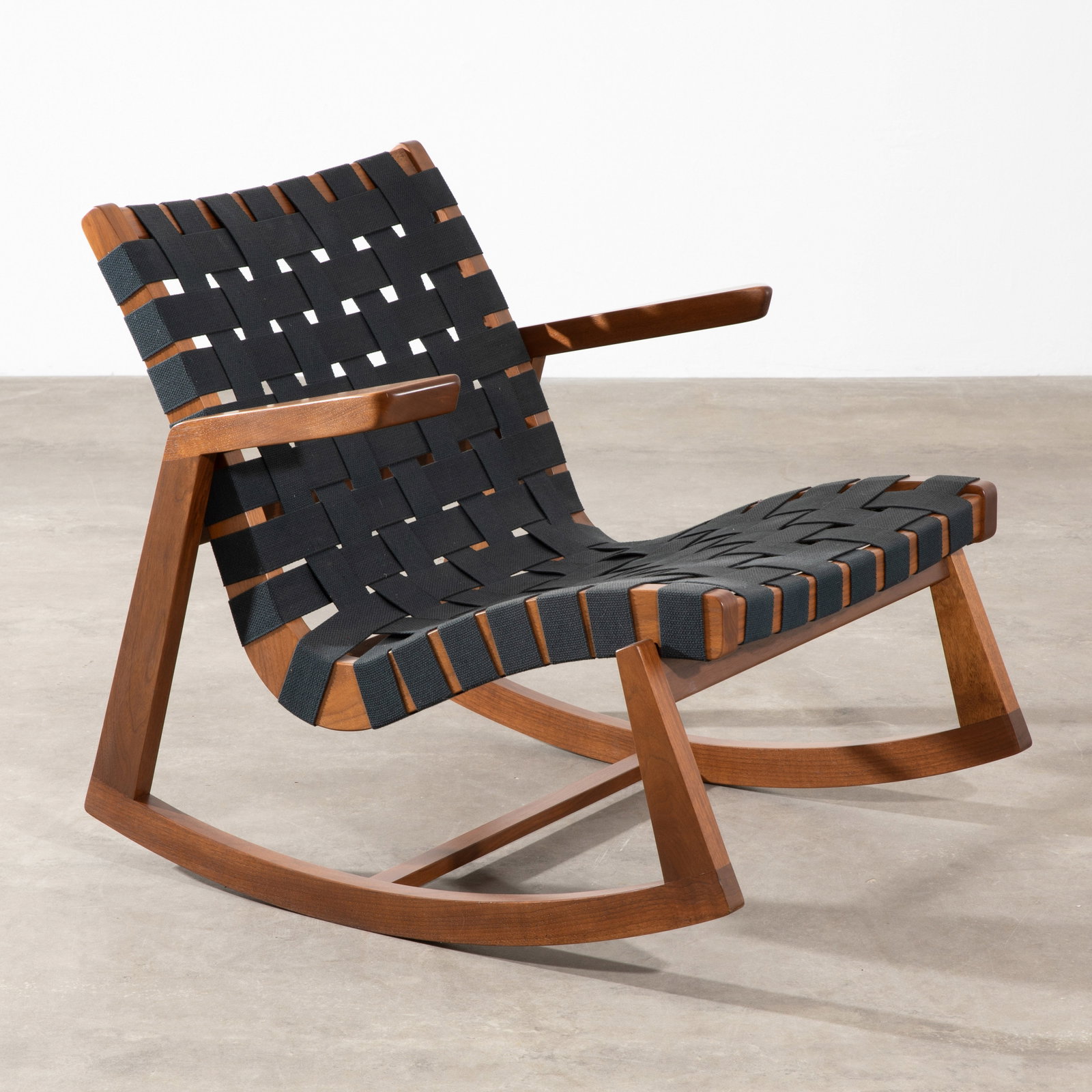 Ralph Rapson, Greenbelt Rocker rocking chair: Ralph Rapson Designed in 1940. Current production by Rapson Inc. Solid walnut with cotton webbing. 73 x 73 x 82 cm, seat height 39 cm. Signed with an engraved signature. (STANDARD TAXATION)