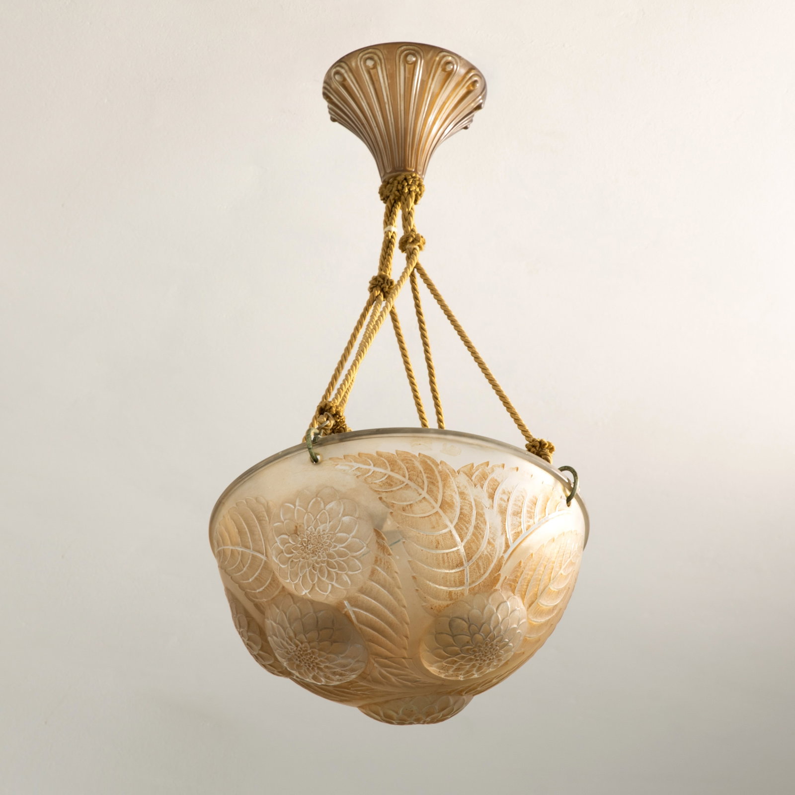 René Lalique, Wingen-sur-Moder, Ceiling light model Dahlia: Designed in 1921. Deeply concave, hemispherical shape. Colorless pressed glass with light brown patination. Relief decoration featuring flowering dahlias. Cord suspension with glass cover. Overall hei