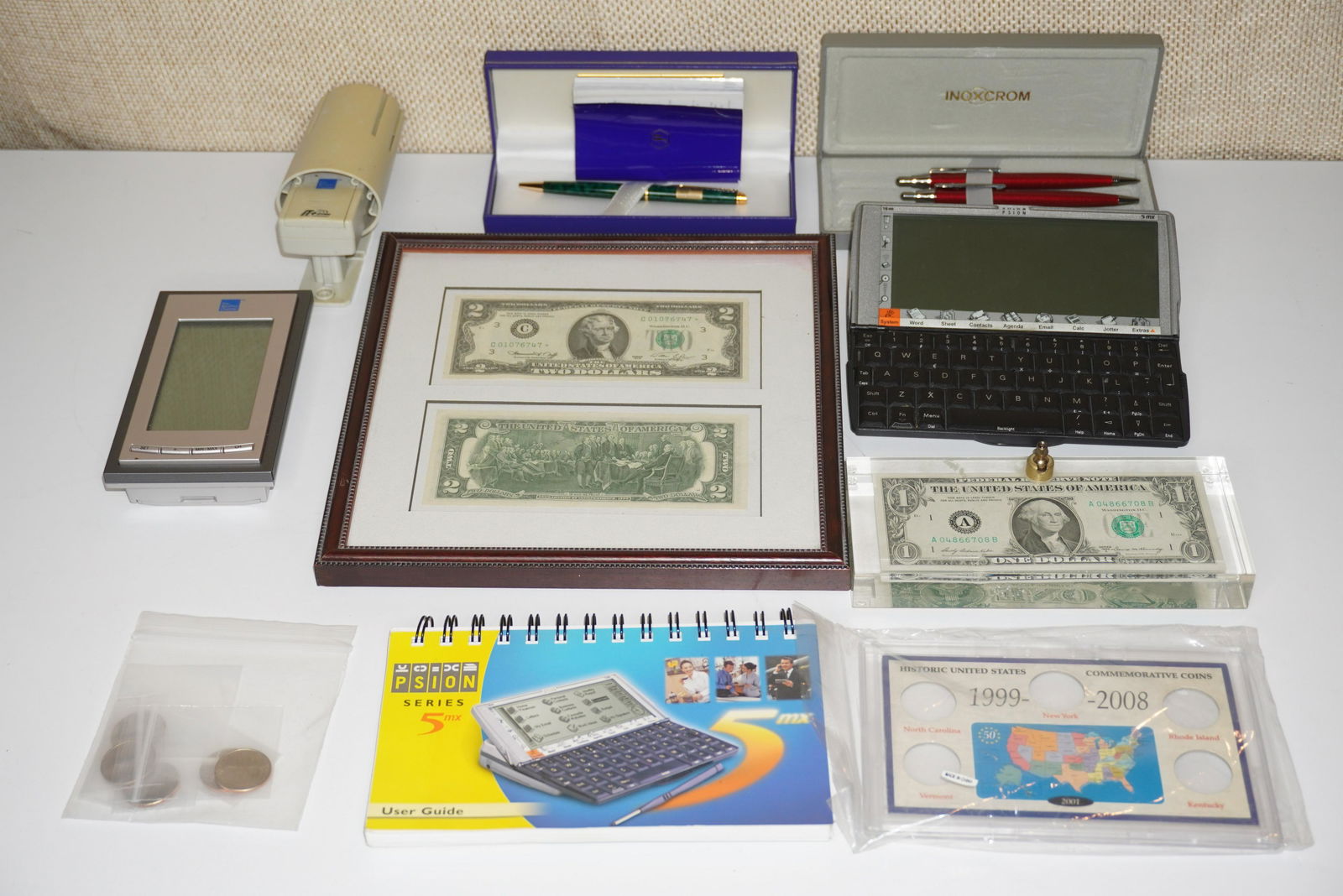 GROUP OF ASST' TABLE ARTICLES: FRAMED TWO DOLLAR BILL, DOLLAR BILL PEN HOLDER, COMMEMORATIVE COINS, WATERMAN PEN, INOXCROM PEN & PENCIL SET, PSION & WEATHER CHANNEL MONITOR