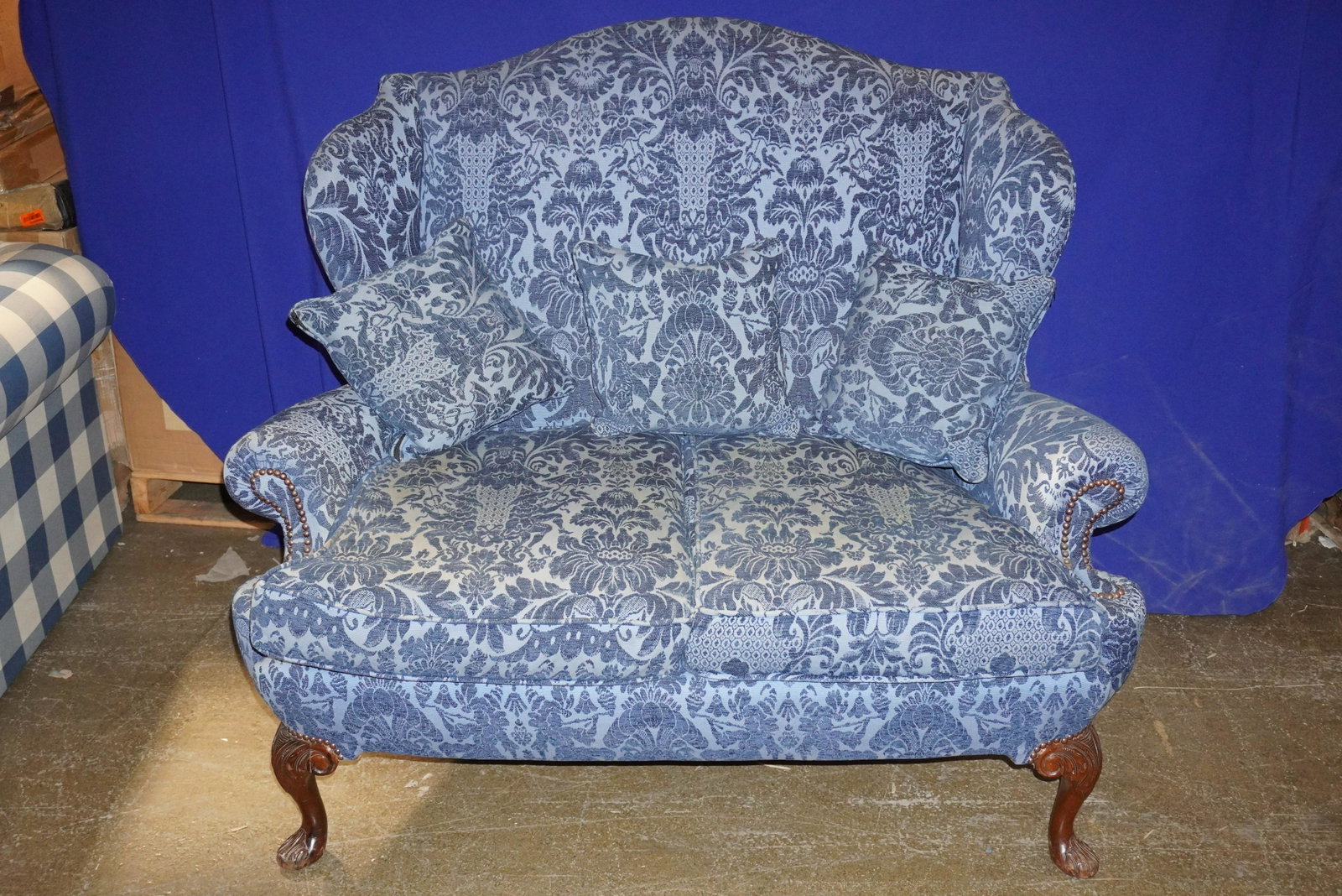 BLUE VELVET HIGHBACK LOVESEAT: BLUE VELVET HIGHBACK LOVESEAT W/ NAILHEAD DETAIL ON CARVED WOOD FEET, 44"H X 38"D X 52"L, GOOD CONDITION