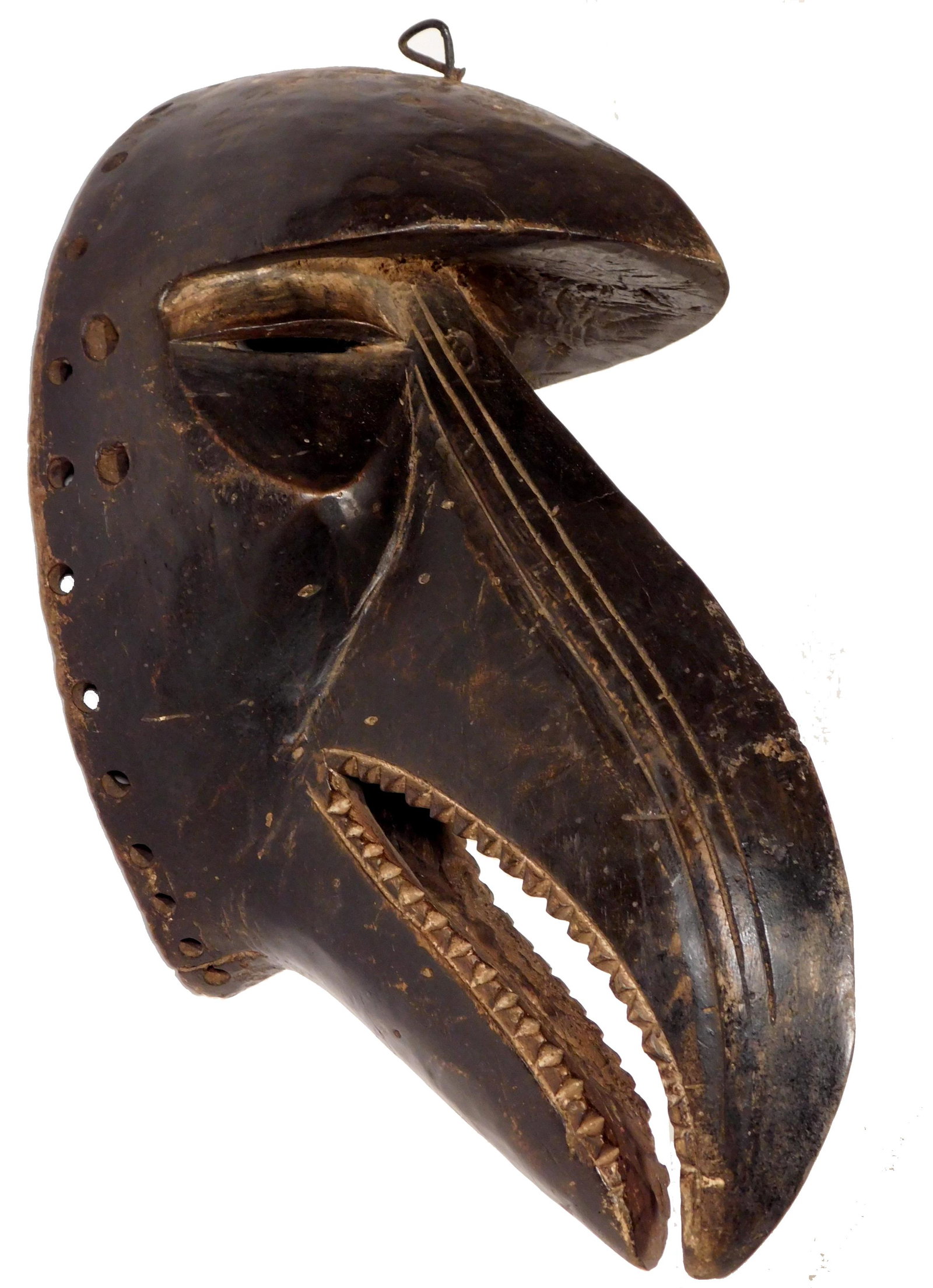Bird Mask (with teeth) Dan People, Liberia: African Tribal Art: Dan People, Liberia: Mask in the form of the abstracted face of a bird, whose open beak is lined with teeth. Carved wood with an overall dark stained patina, with lighter teeth, ey