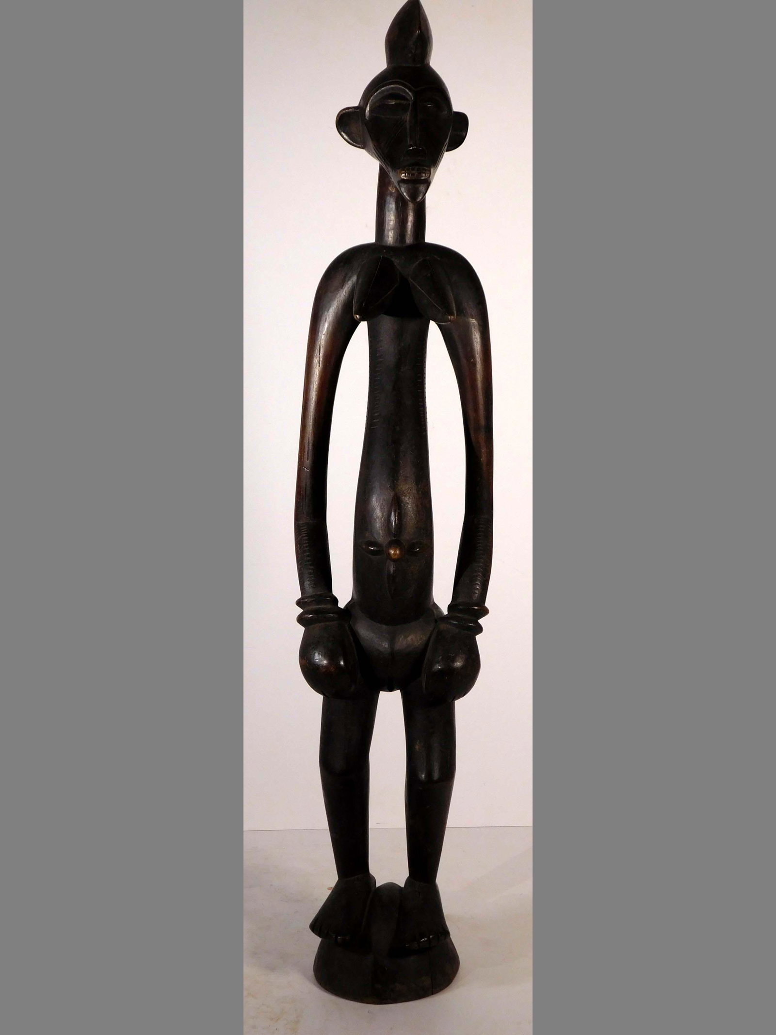 Rhythm Pounder in the Form of a Woman, Senufo, Ivory Coast: African Tribal Art: Senufo people, Ivory Coast. Carved wood, with a dark, patinated finish. Early 20th Century. Standing, elongated figure of a woman. A well carved face and hair do completer the head