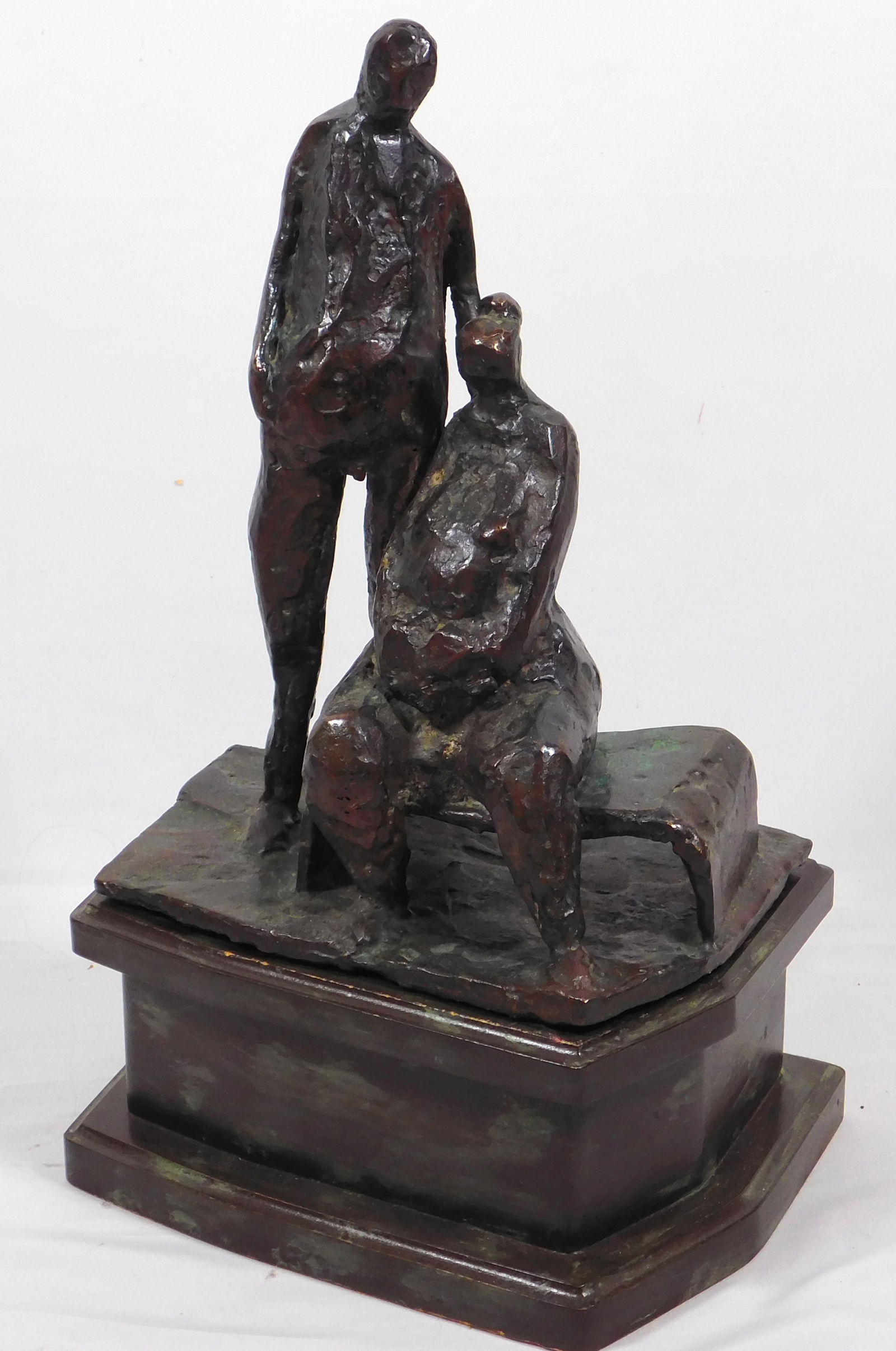 Henry Moore (English, 1898-1986) Style of: Sitting and Standing Figures: Henry Moore (English, 1898-1986) Manner of: Sitting and Standing Figures. Bronze with wooden base. Henry Spencer Moore was an English artist. He is best known for his semi-abstract monumental bronze